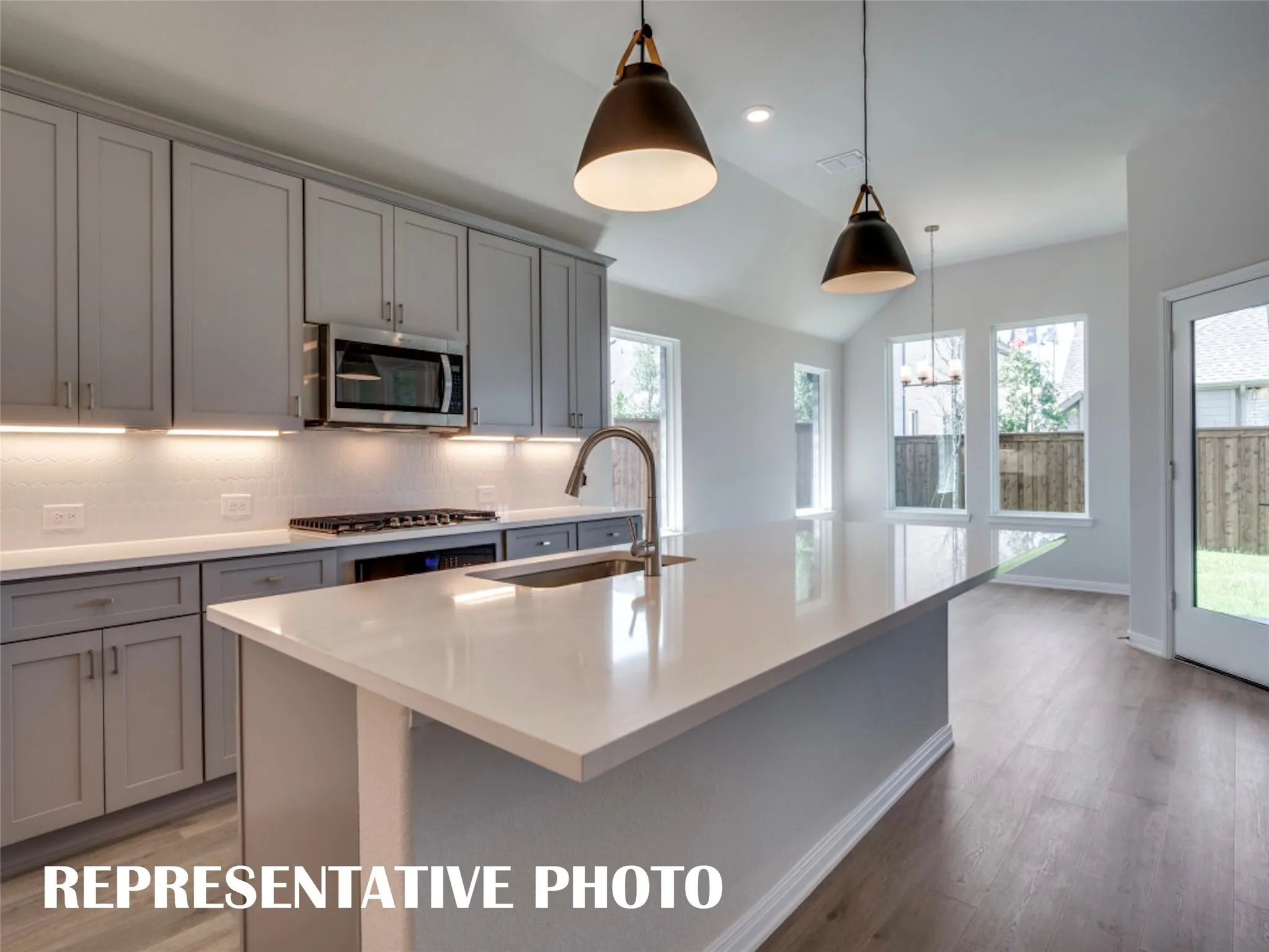Beautiful cabinetry and gorgeous countertops paired with stainless appliances make this a kitchen any chef would be proud to call their own!  REPRESENTATIVE PHOTO