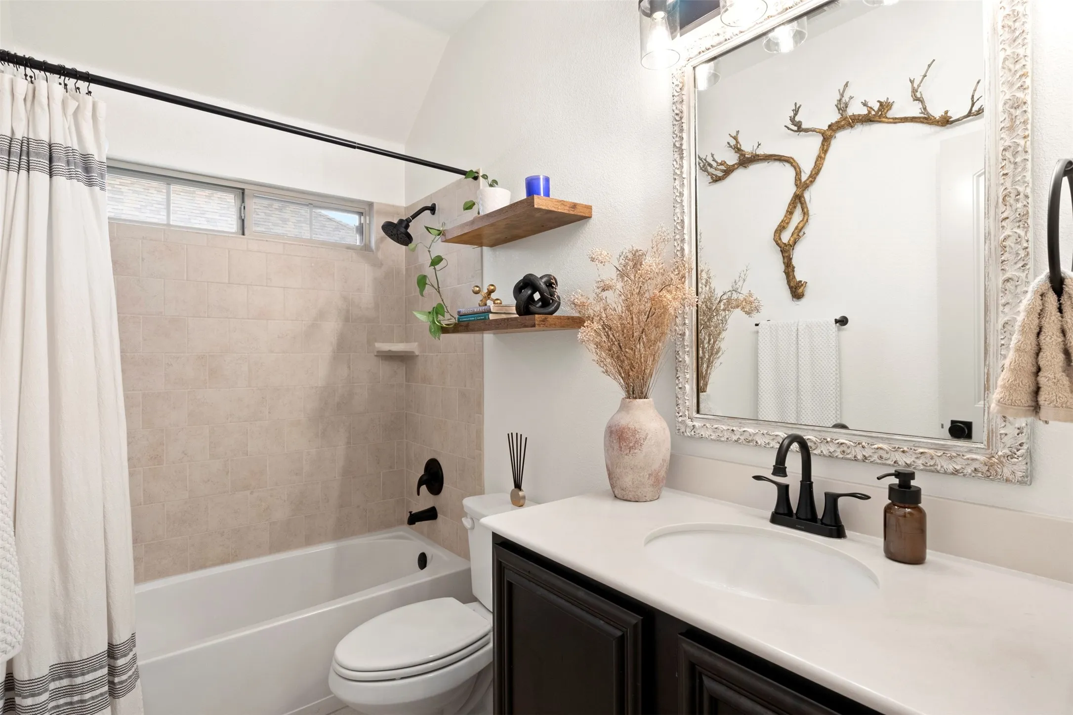 Full secondary bath with tub-shower combination and updated black fixtures.