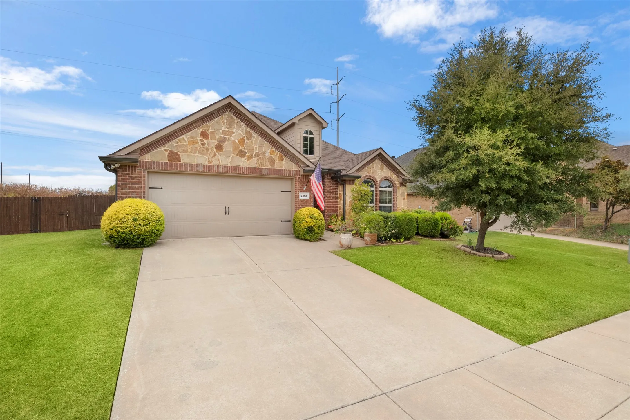 Brick and stone exterior, established landscaping and a mature shade tree give 2189 Liriope Ln a welcoming, established feel from the moment you arrive