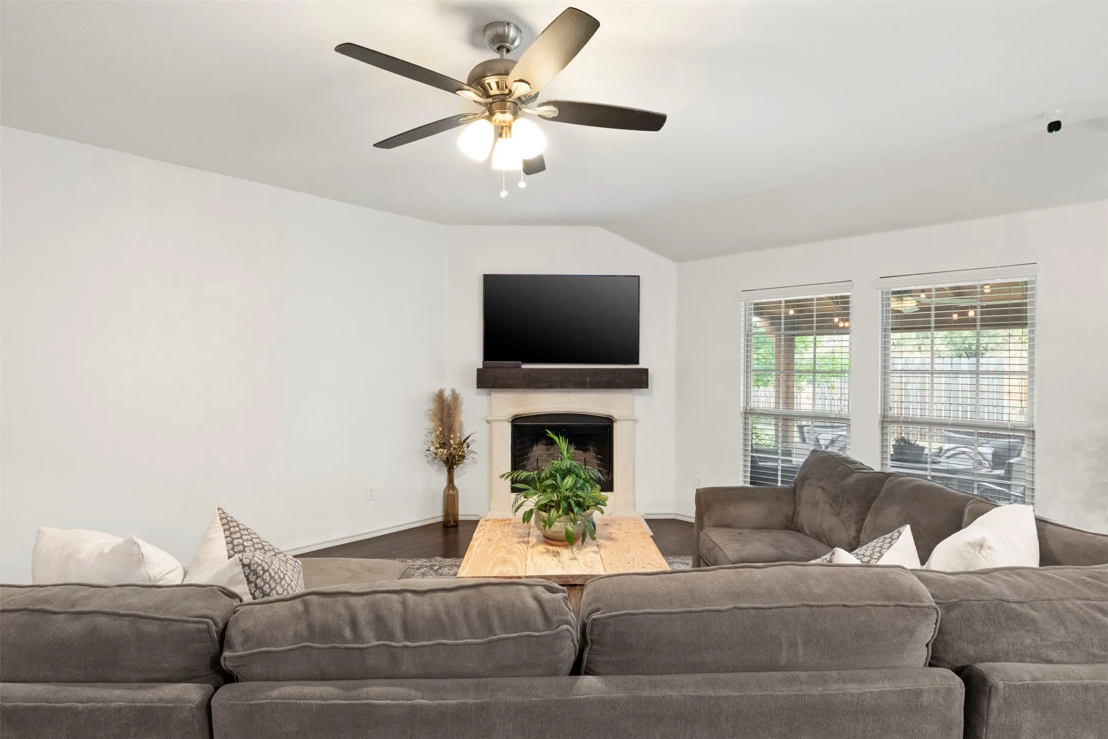 The generously sized living area gives buyers plenty of room to gather, with dark flooring, fresh neutral paint and a WOOD-BURNING FIREPLACE anchoring the space.