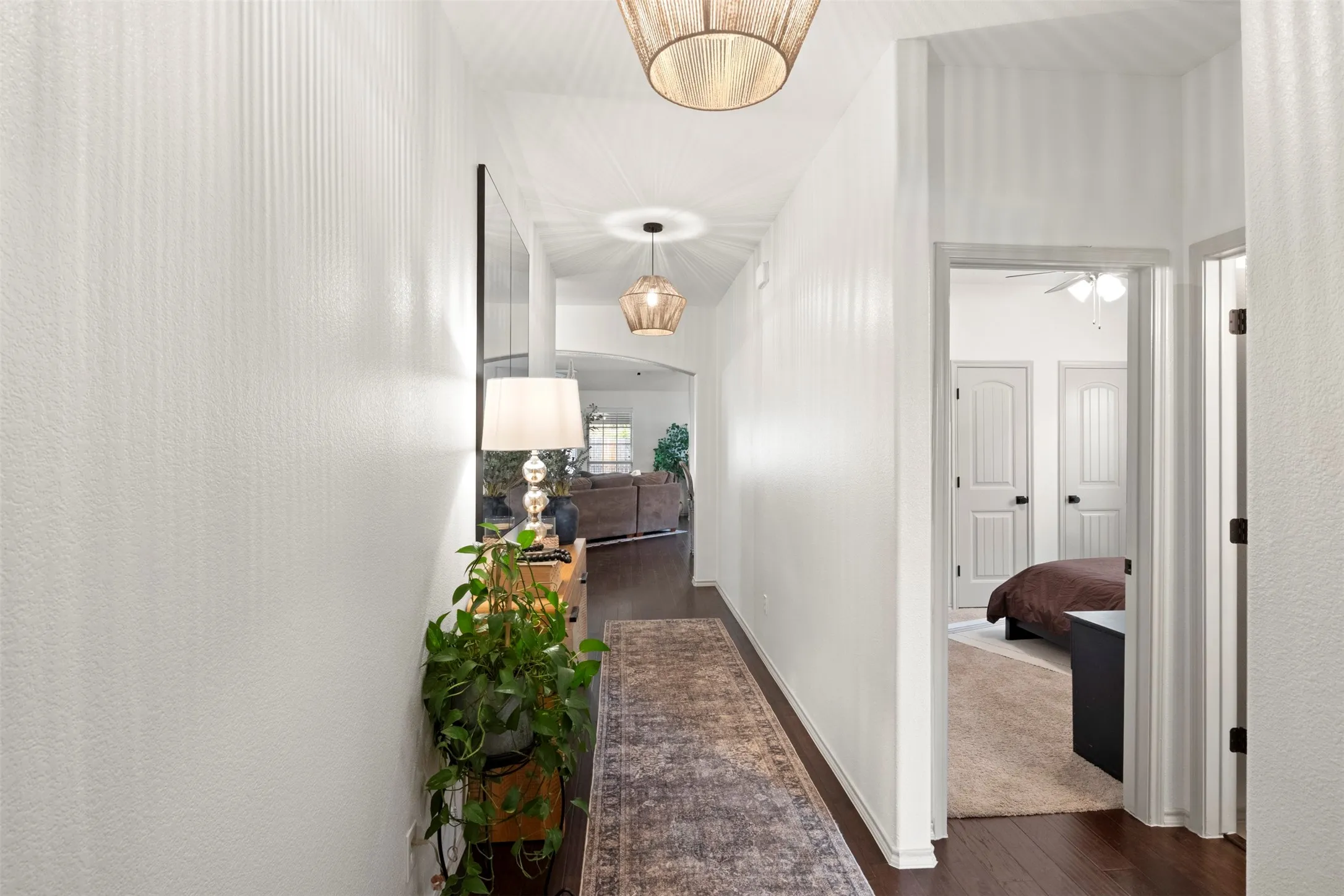 UPDATED FROM THE MOMENT YOU WALK IN. Fresh paint, updated lighting and dark flooring create a clean, current first impression, with the hallway opening directly into the home's main living spaces.