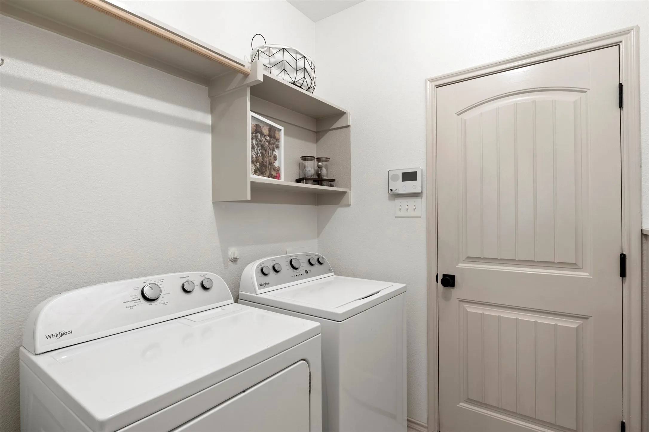 Dedicated laundry room with built-in storage and space for a full-size washer and dryer.