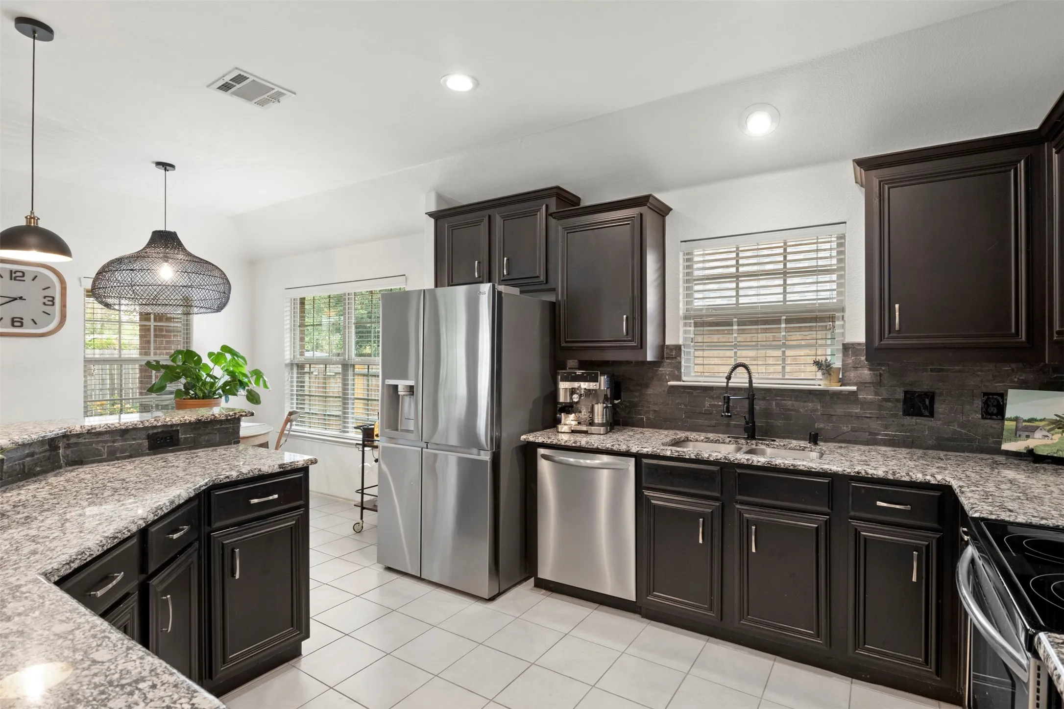 Designed for everyday function, the kitchen offers abundant cabinetry and counter space, stainless steel appliances and bar seating, all within easy reach of the adjoining living area.