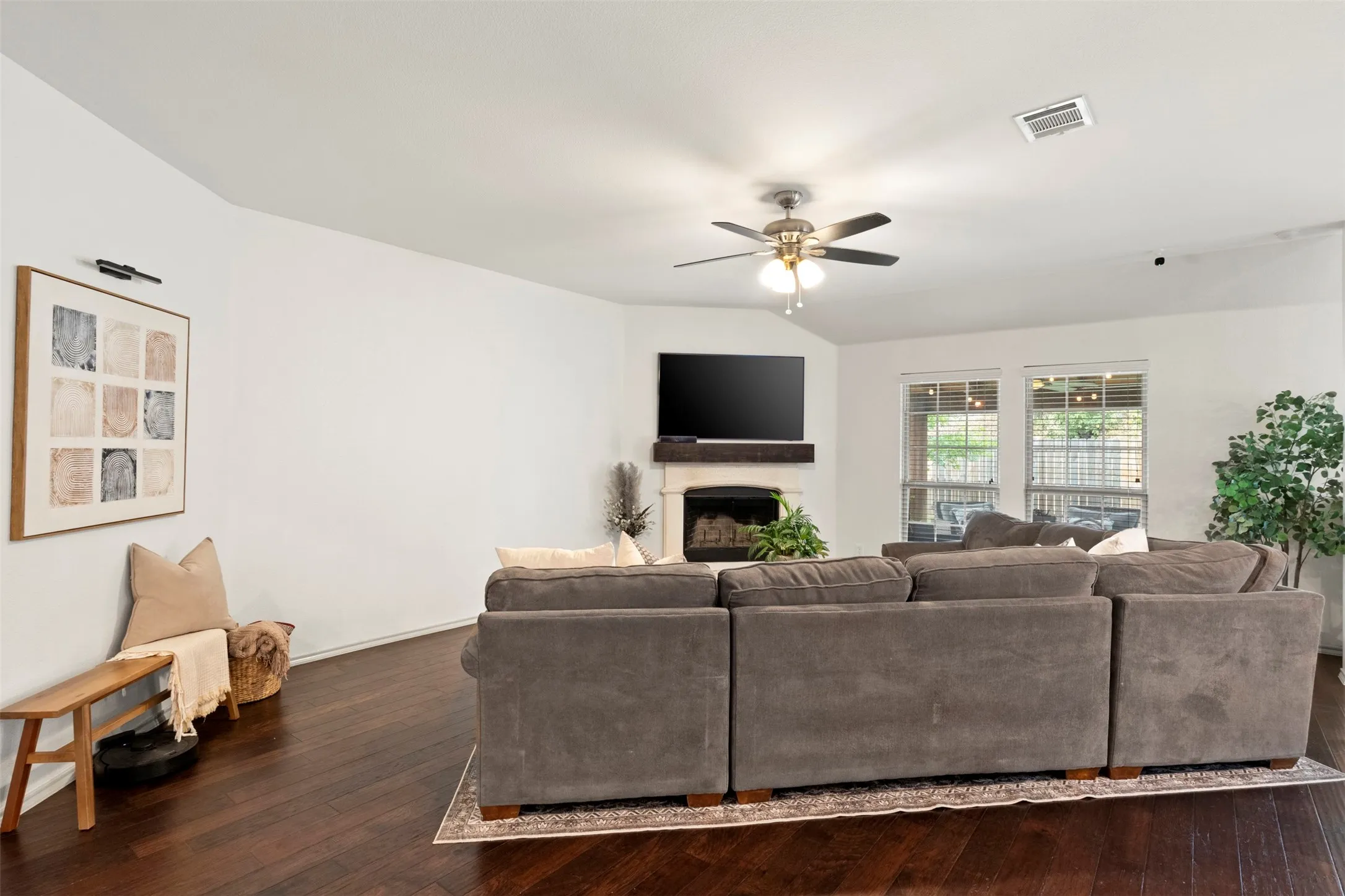 Fresh paint and dark flooring give the living room a clean, updated backdrop, while the wide arched opening maintains an easy connection to the bedroom hallway and rest of the home.