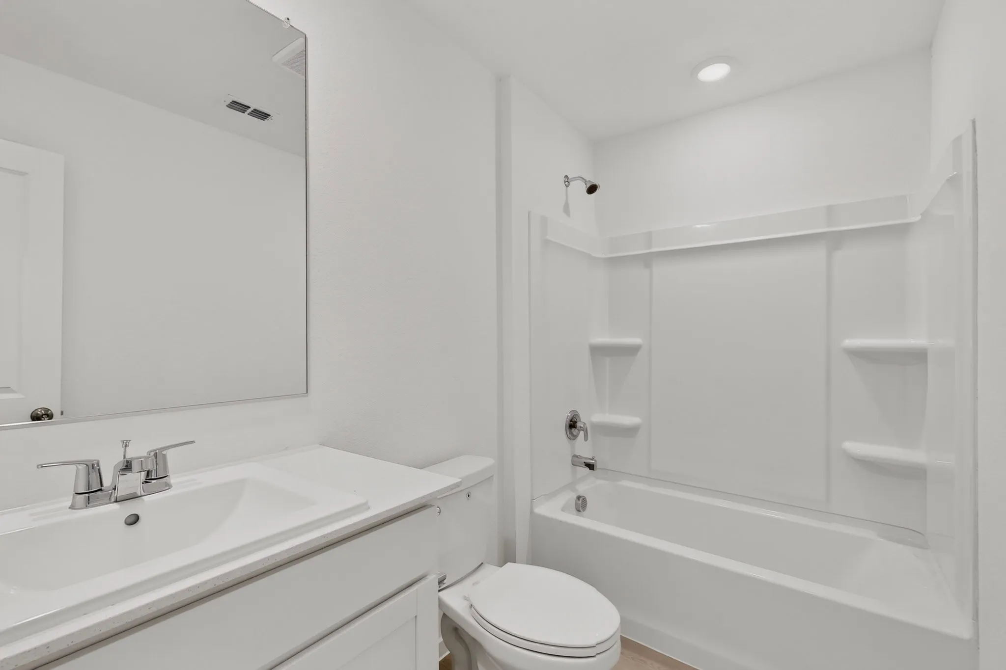 White vanity with integrated sink and chrome fixtures