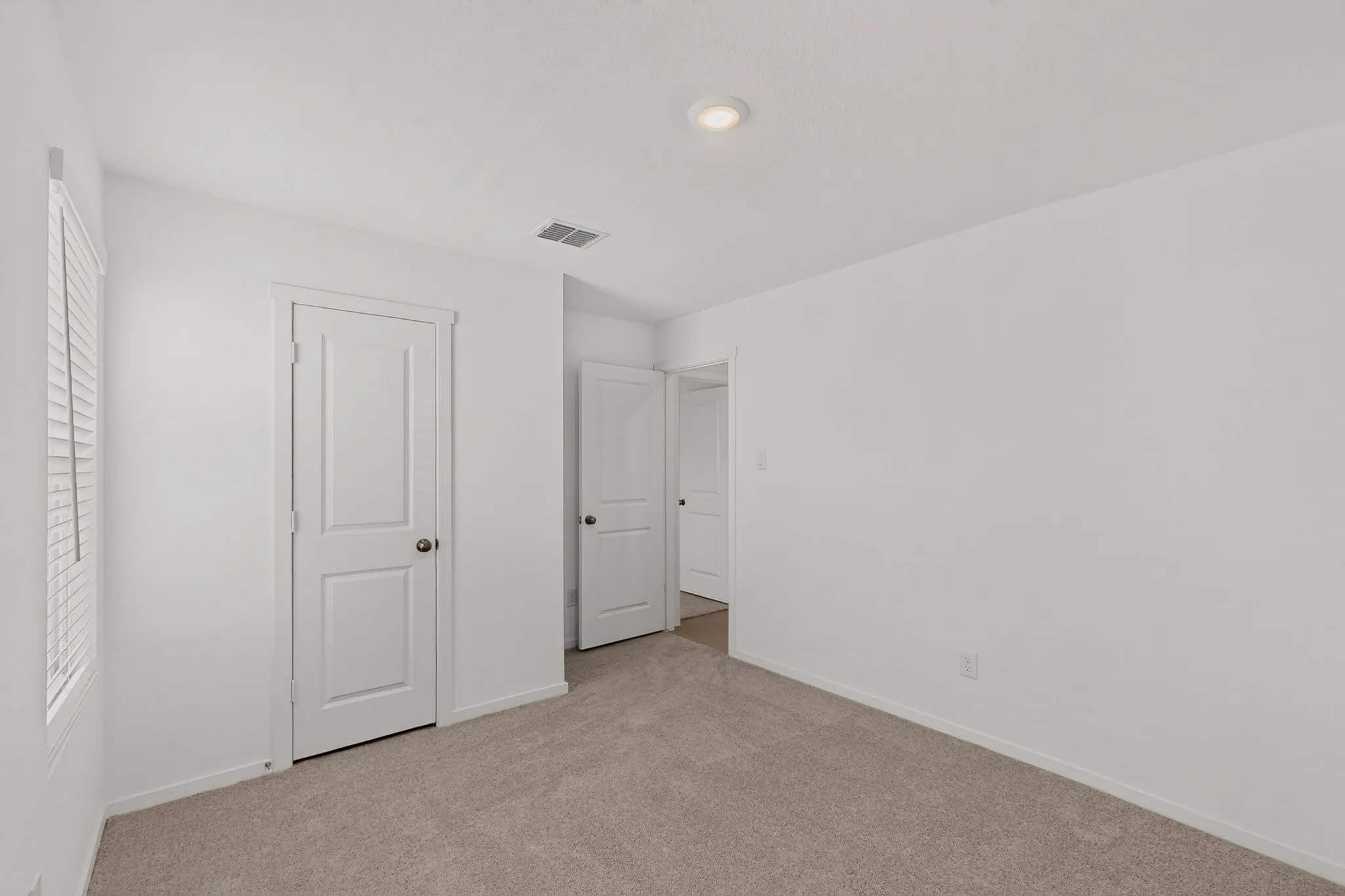 Neutral wall paint, recessed lighting, white interior doors, and plush carpet flooring