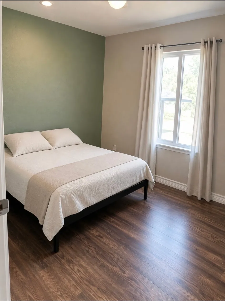 Wood-finish flooring, recessed lighting, double-hung window, and a painted accent wall