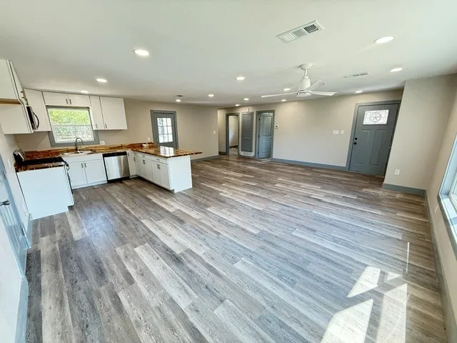 Open-concept living area with wood-finish flooring, recessed lighting, and a ceiling fan