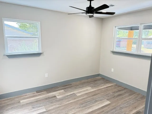 Recessed lighting, wood-finish flooring, and a ceiling fan with integrated lighting
