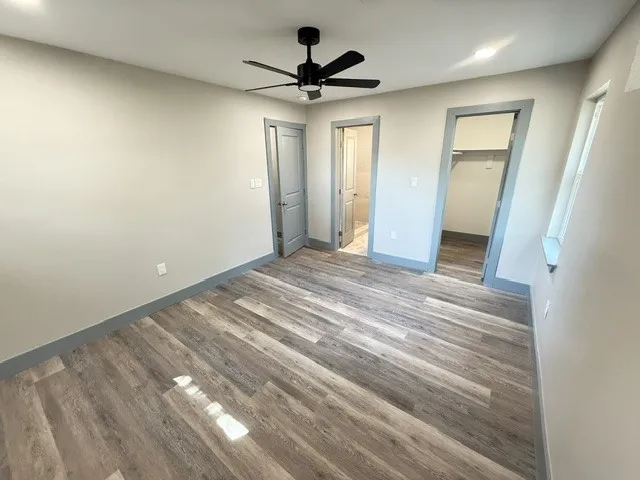 Wood-finish flooring, recessed lighting, and a contemporary ceiling fan
