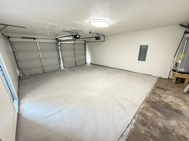 Two-car garage featuring a painted floor, two overhead garage doors, and a ceiling-mounted light fixture