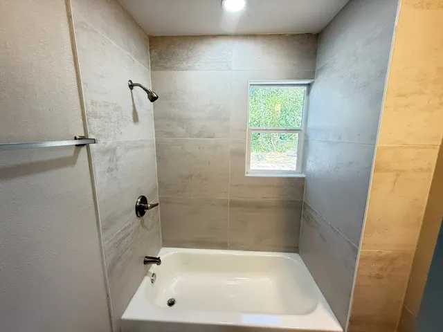 White bathtub with a chrome shower head and faucet
