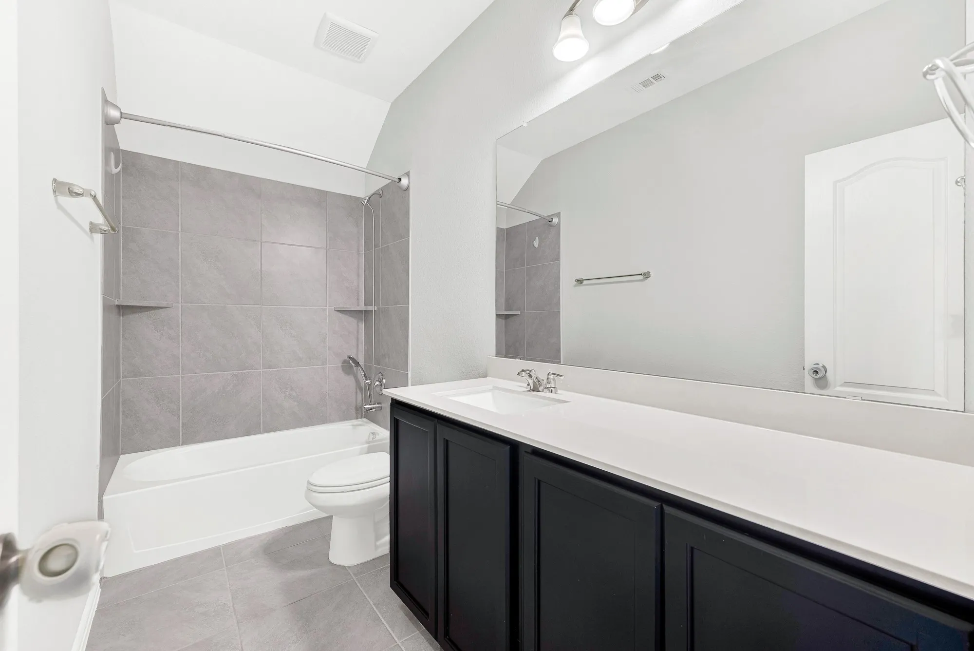 Spa-inspired primary bathroom featuring a double vanity with white quartz countertop, matte black cabinetry, and integrated sink fixtures
