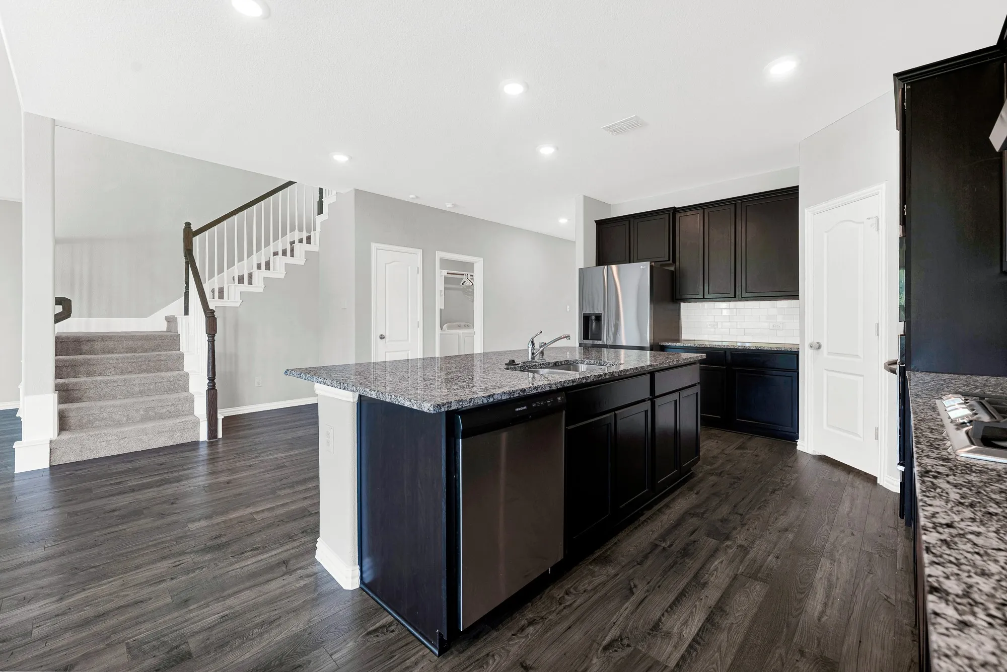 Kitchen featuring dark cabinetry, speckled countertops, and stainless steel appliances