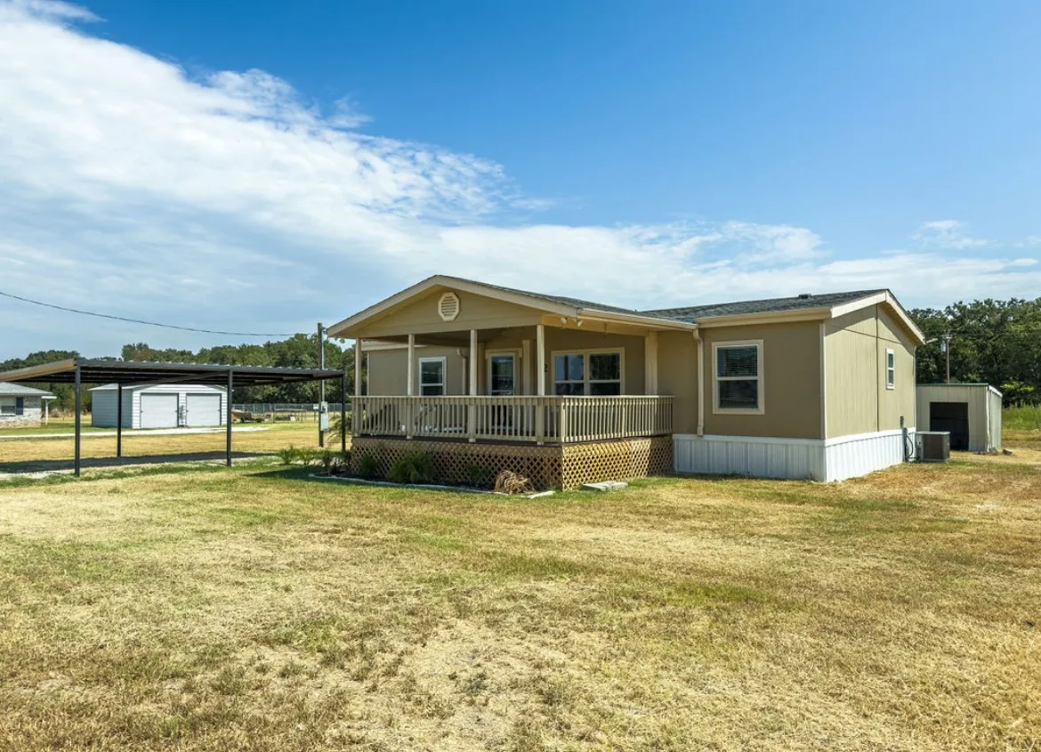 Carport structure, exterior storage shed, covered front porch, and elevated foundation