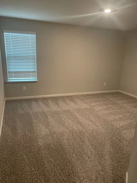 Recessed lighting, neutral wall paint, window with blinds, and carpeted flooring