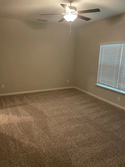 Vaulted ceiling with a ceiling fan, neutral wall tones, and carpeted flooring