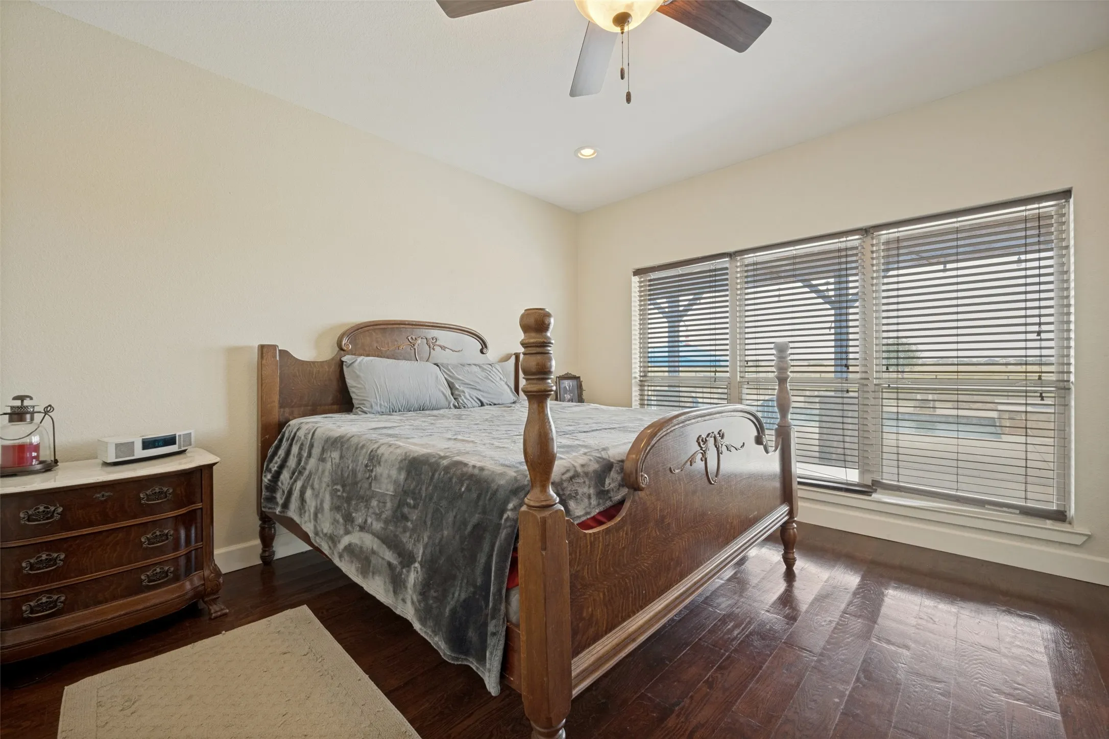 Primary bedroom with wood flooring, recessed lighting, and a ceiling fan with light kit