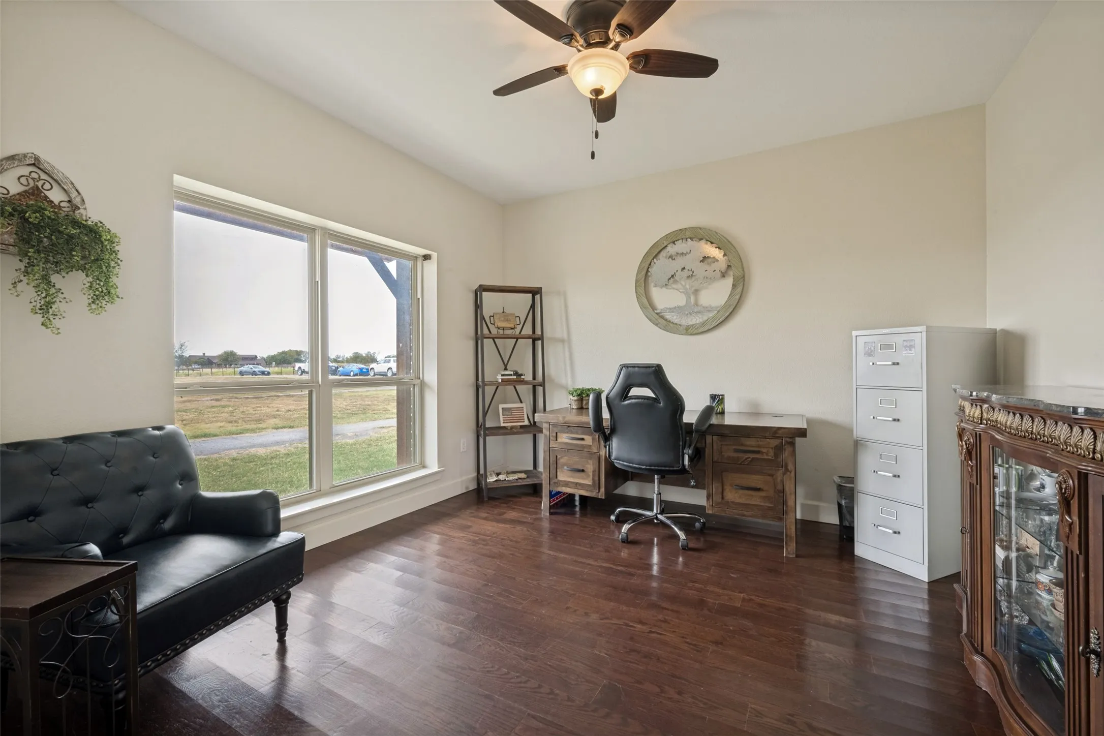 Office with wood flooring, vaulted ceiling, large window, ceiling fan with integrated lighting