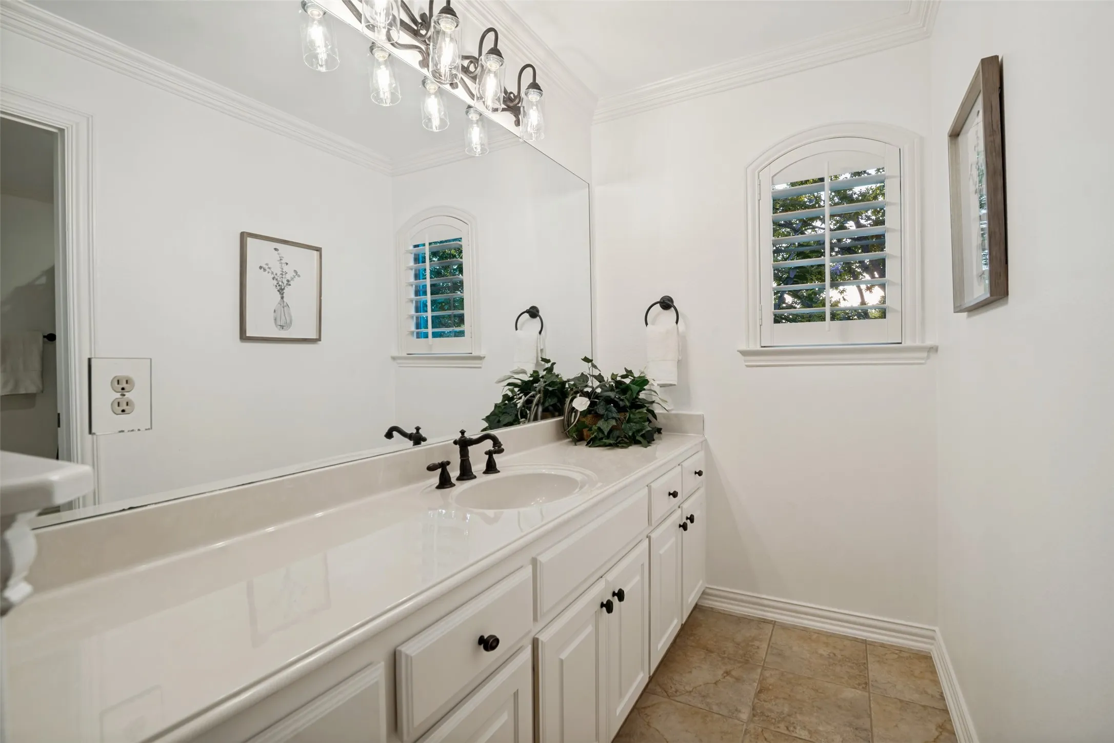 Jack and Jill Vanity with an integrated sink, polished countertop, and dark-finish fixtures
