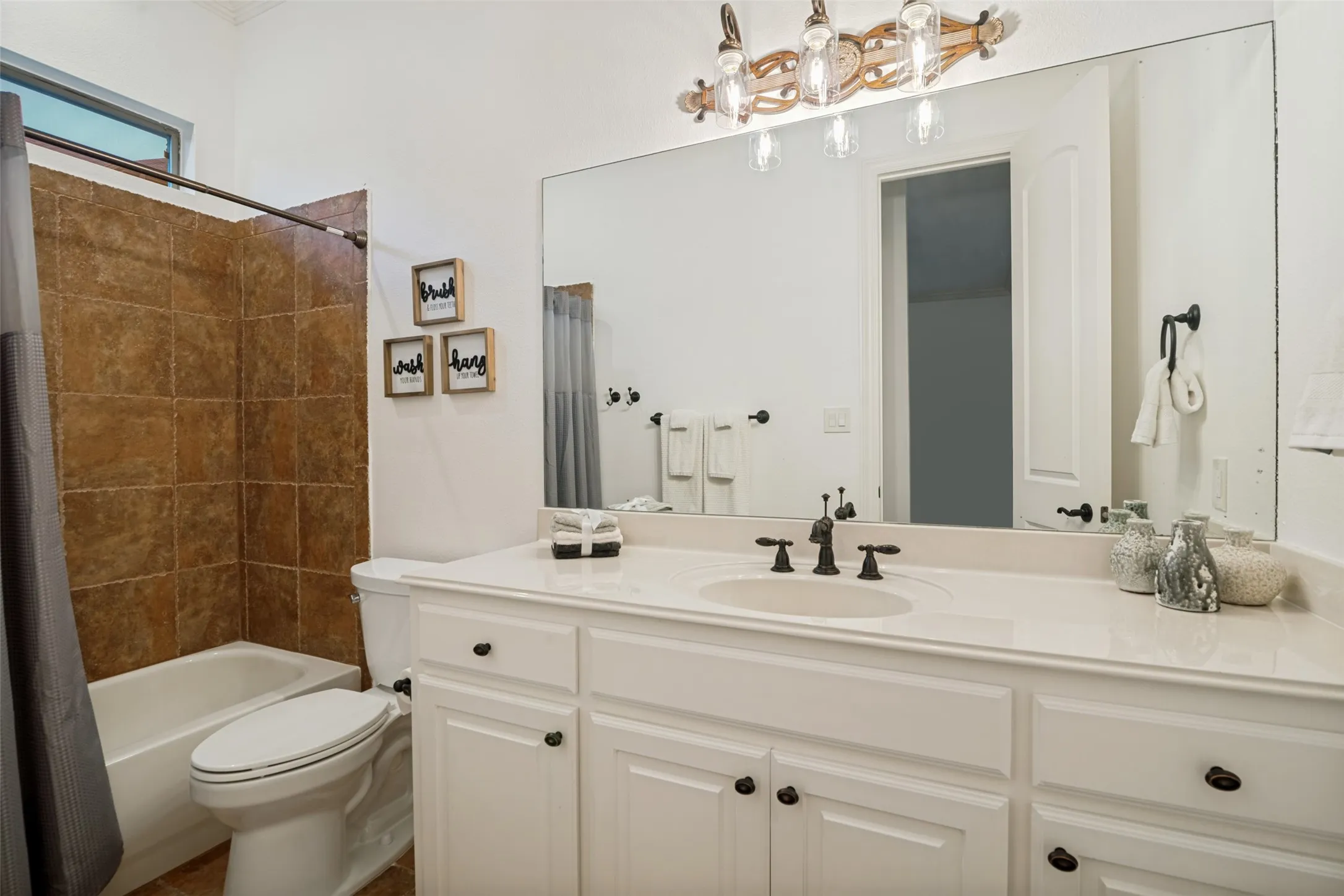 Private ensuite bathroom for second primary. White vanity with shaker-style cabinetry, a built-in sink, and a light-colored countertop