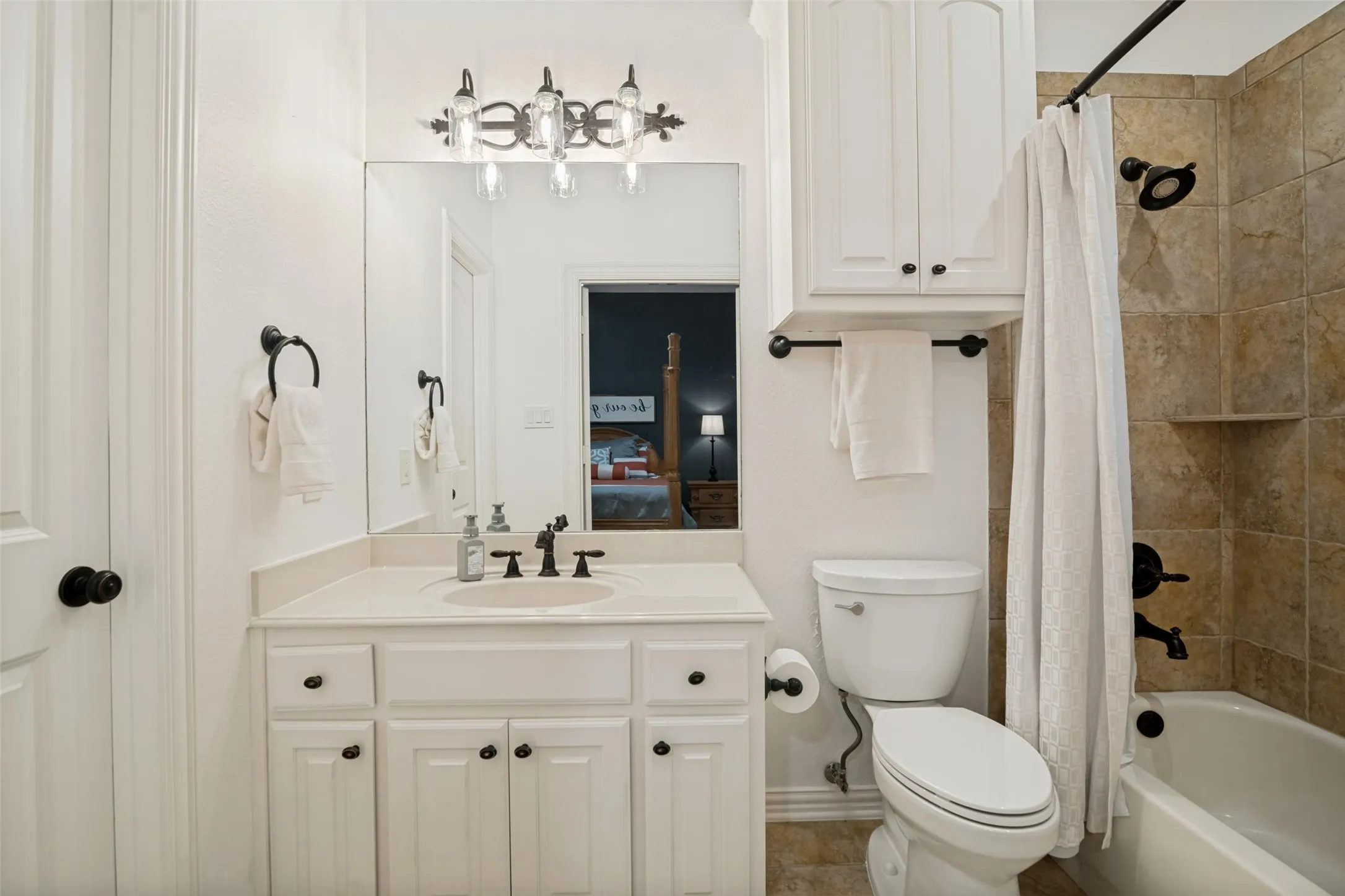 Ensuite bathroom with vanity with integrated sink, bronze-finish faucet, and coordinating hardware