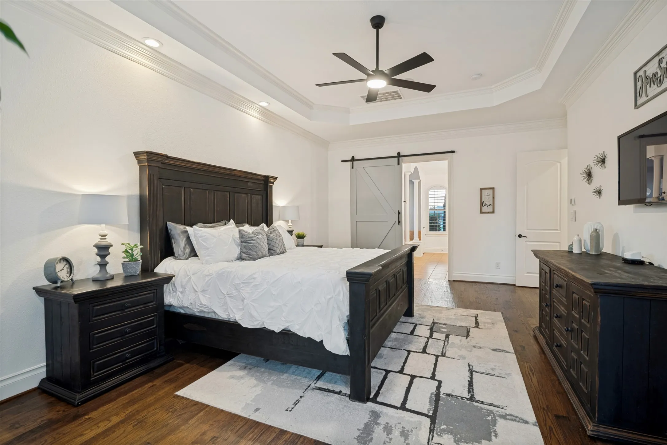 Hardwood flooring with a tray ceiling and recessed lighting