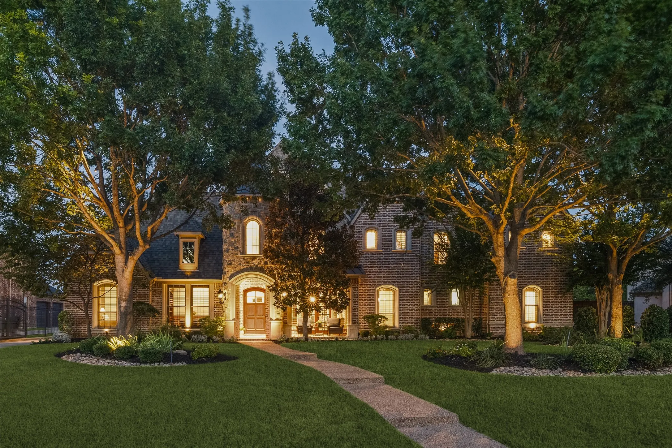Brick and stone exterior with architectural dormers, arched windows, and a prominent front entry
