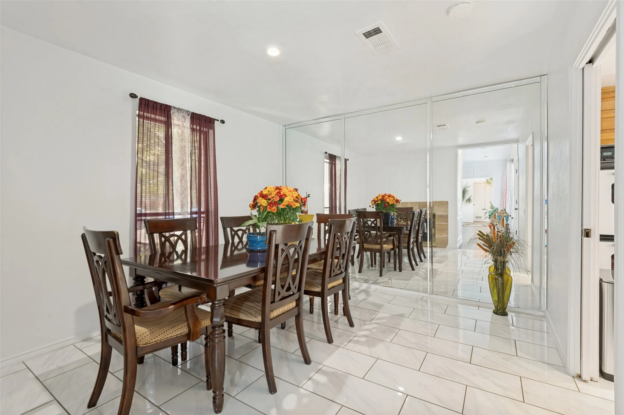 White tile flooring, recessed lighting, and a mirrored wall