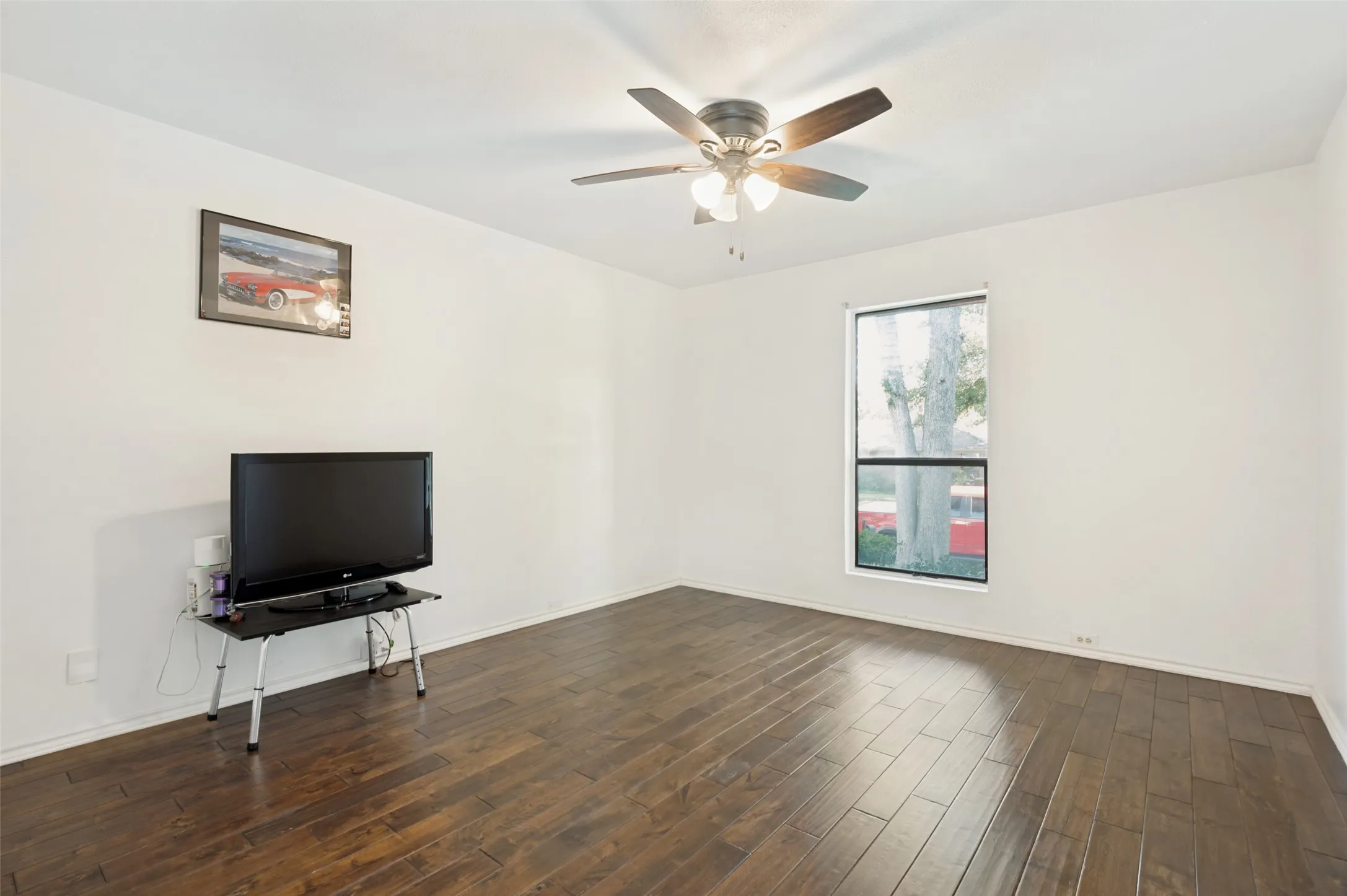 2nd bedroom facing the front of the house with wood-finish flooring, ceiling fan with integrated lighting, and a single pane window