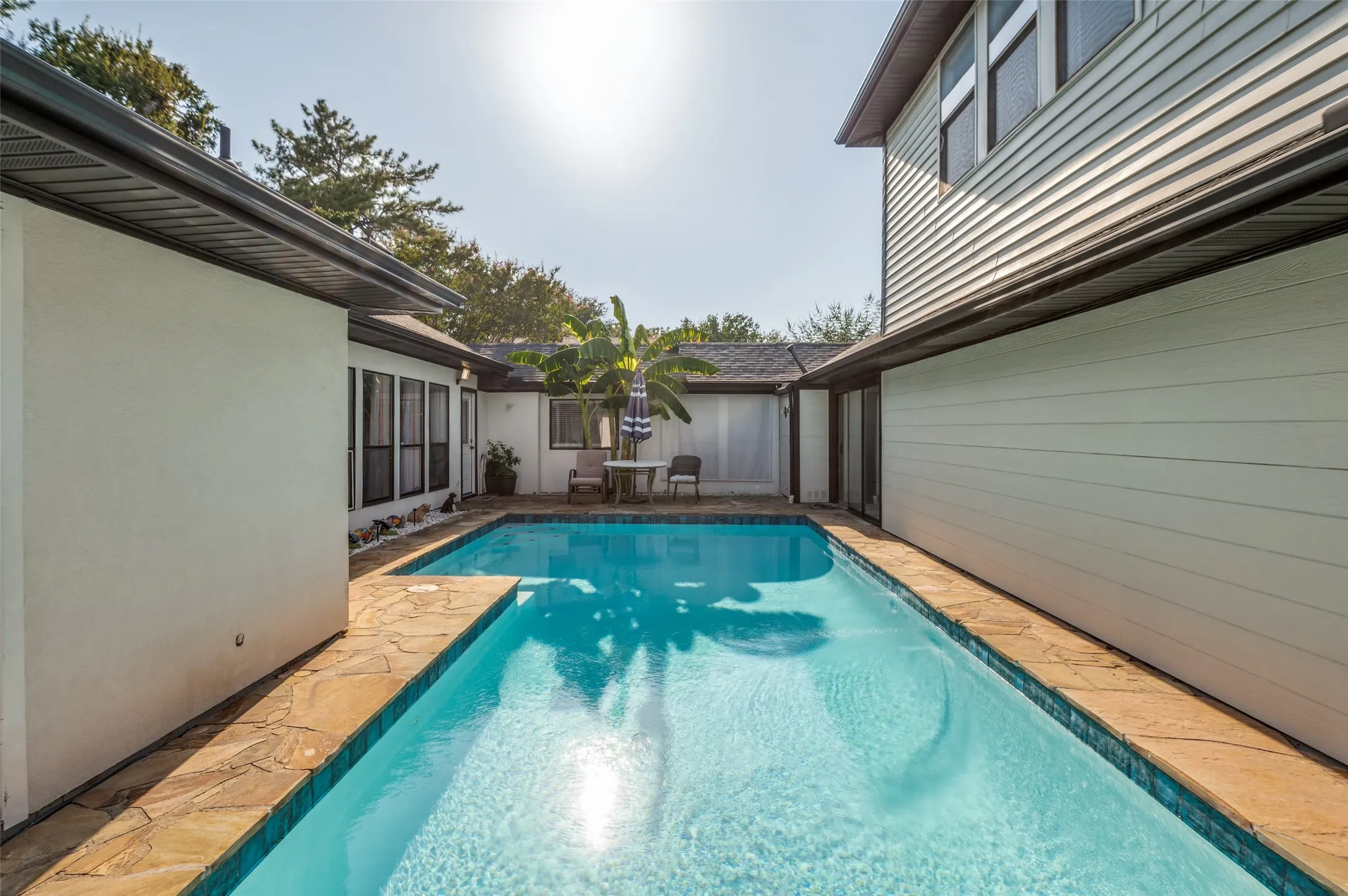 Outdoor swimming pool with flagstone coping.