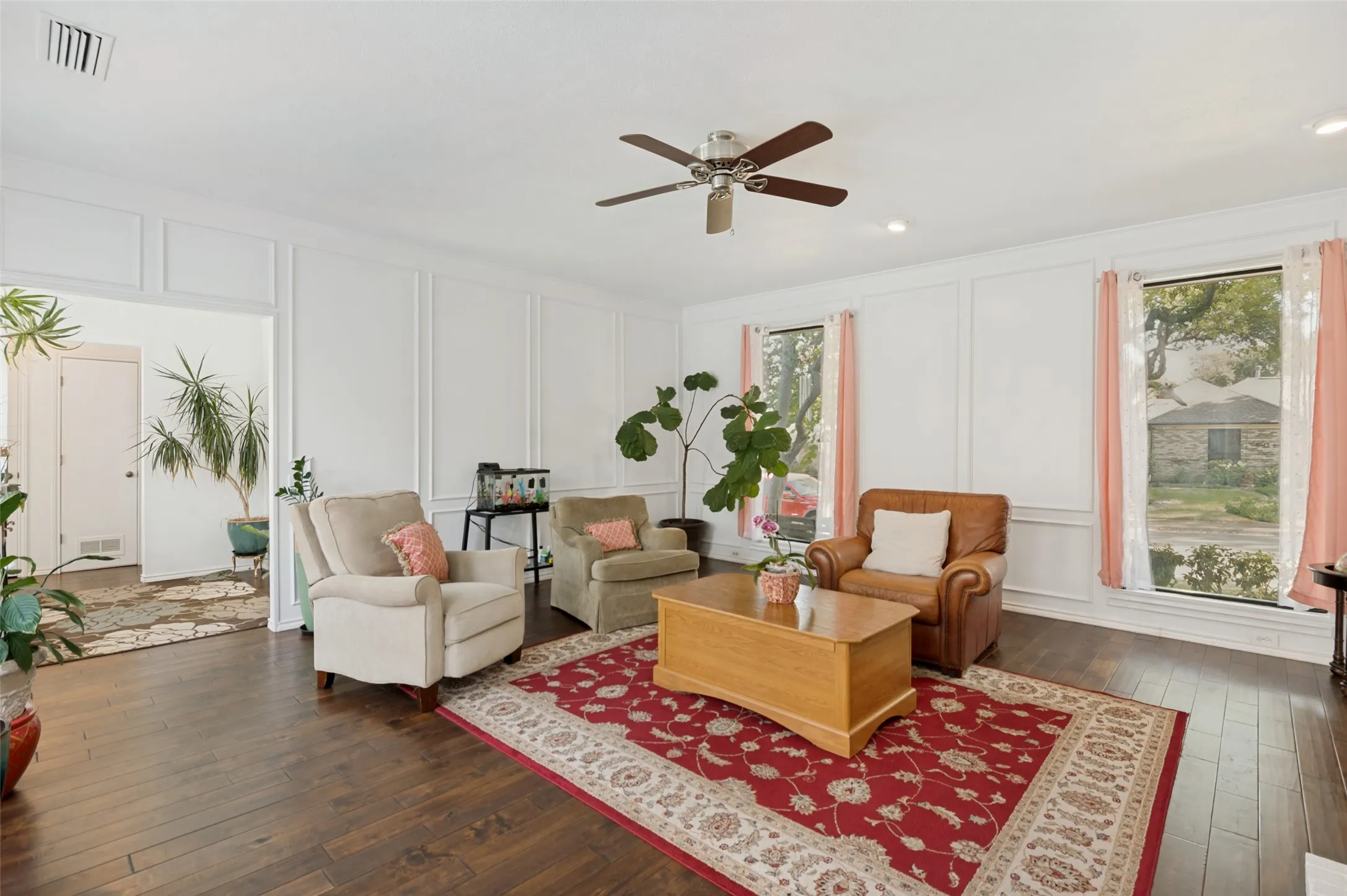 Hardwood-finish flooring, paneled wall detailing, dual windows, and recessed lighting
