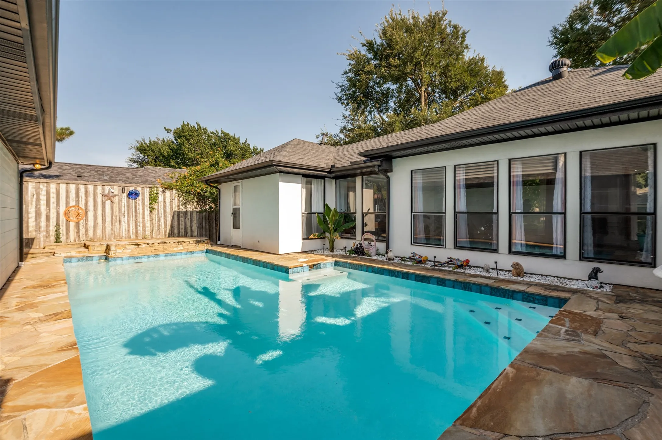 Exterior swimming pool with stone coping and perimeter tile.