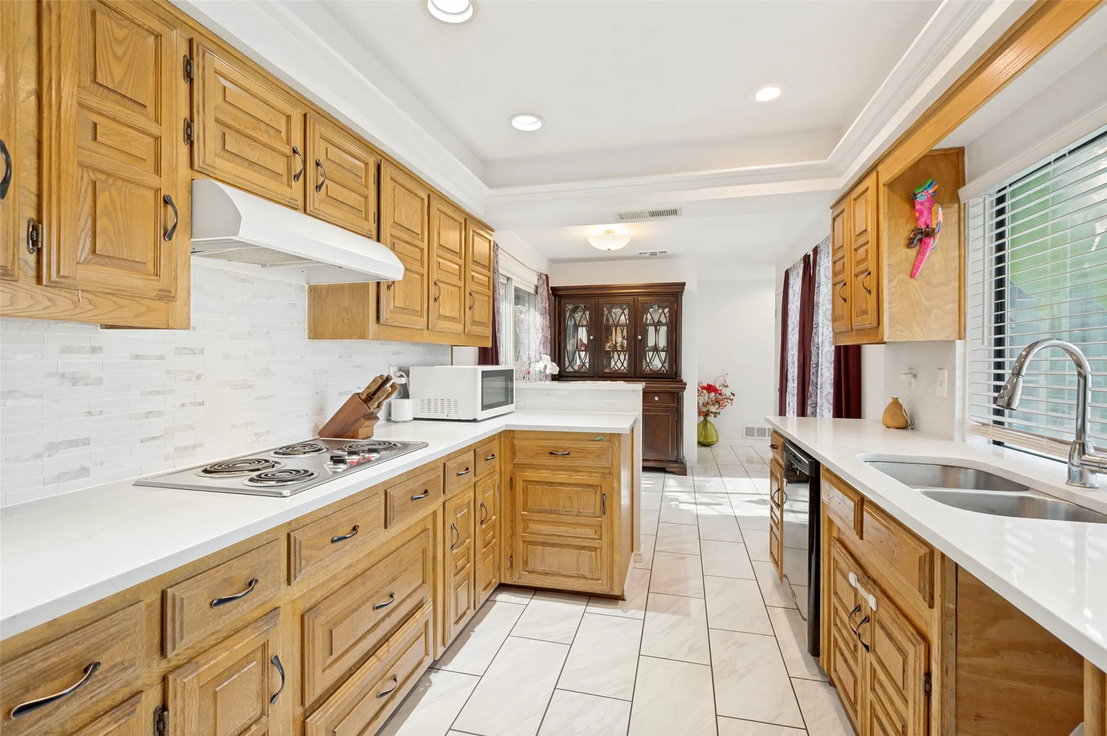 Kitchen featuring recessed lighting, a built-in oven, stainless steel sink, wood cabinetry, and tiled flooring