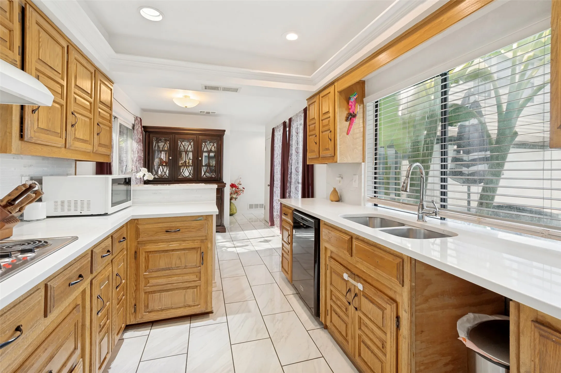 Wood-finish cabinetry paired with white countertops and a tile backsplash