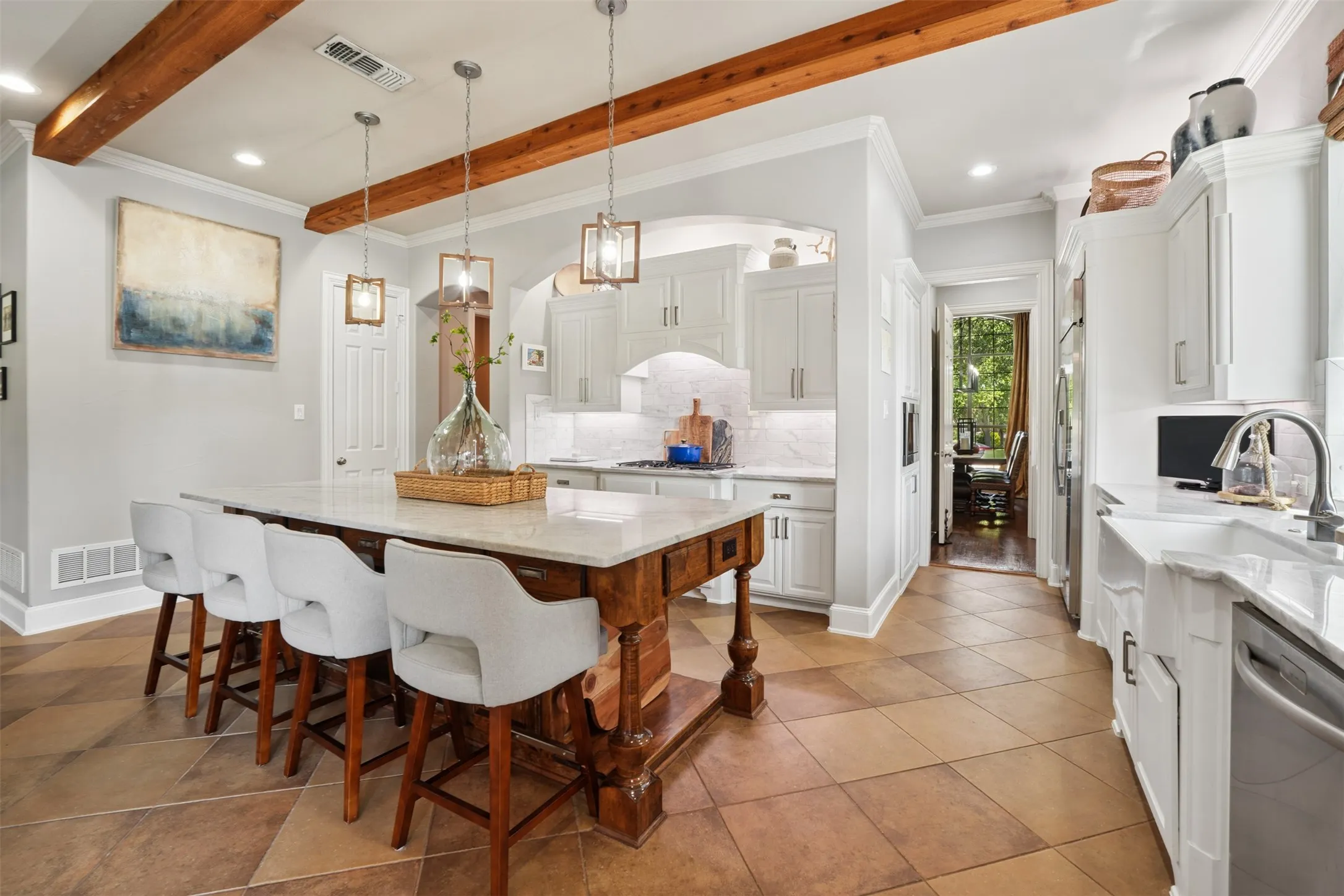 Remodeled kitchen combines marble countertops, custom wood details and an island with a breakfast bar for gathering.