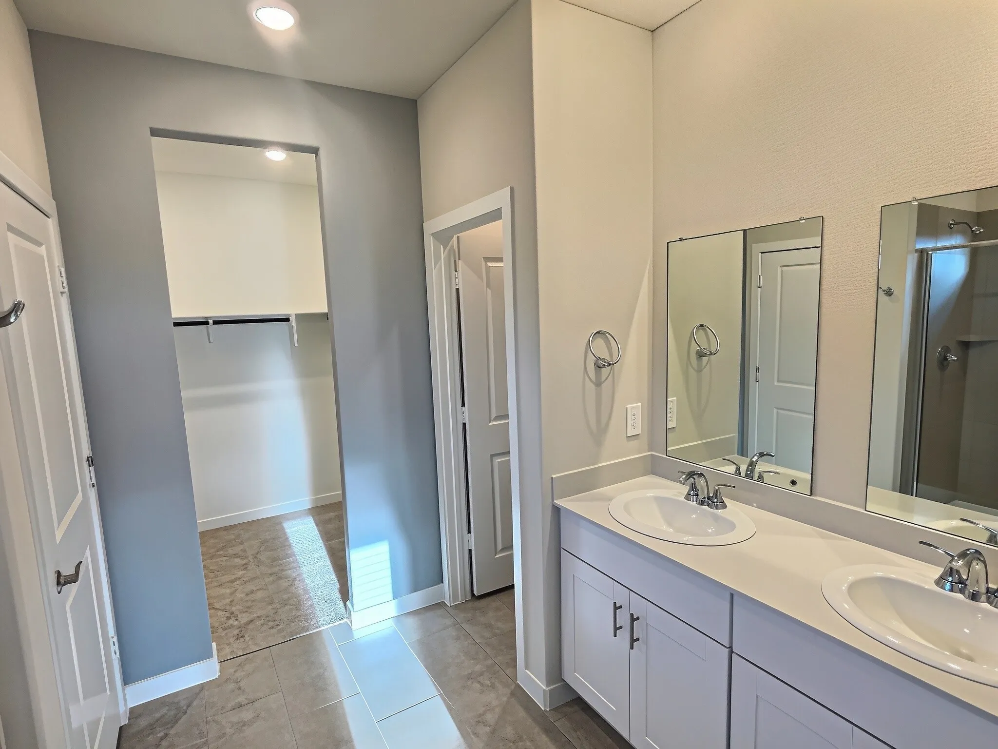 Dual vanity with undermount sinks, chrome fixtures, and light-toned countertops