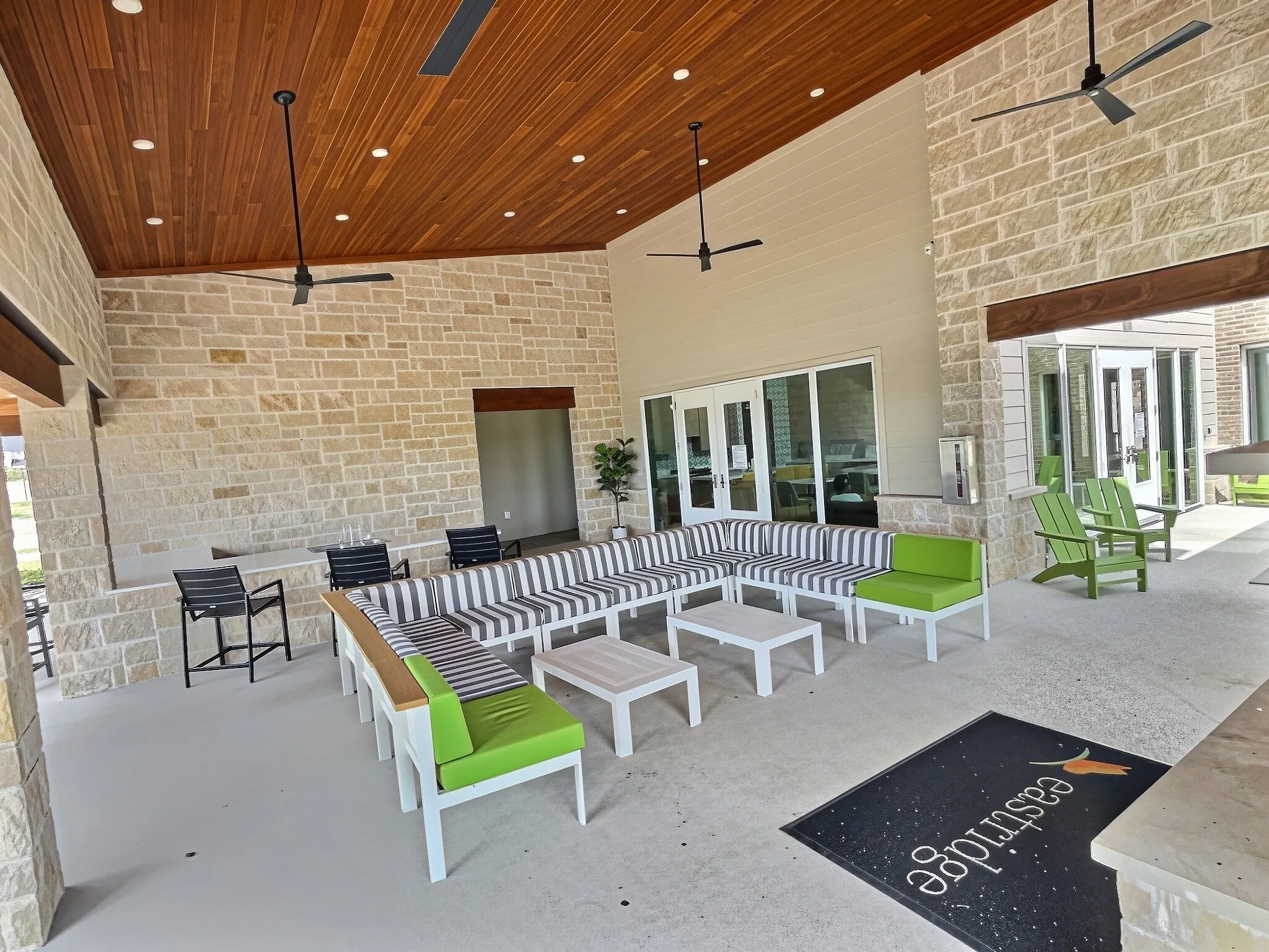Expansive outdoor living area featuring a wood-finish ceiling, recessed lighting, and stone accent walls