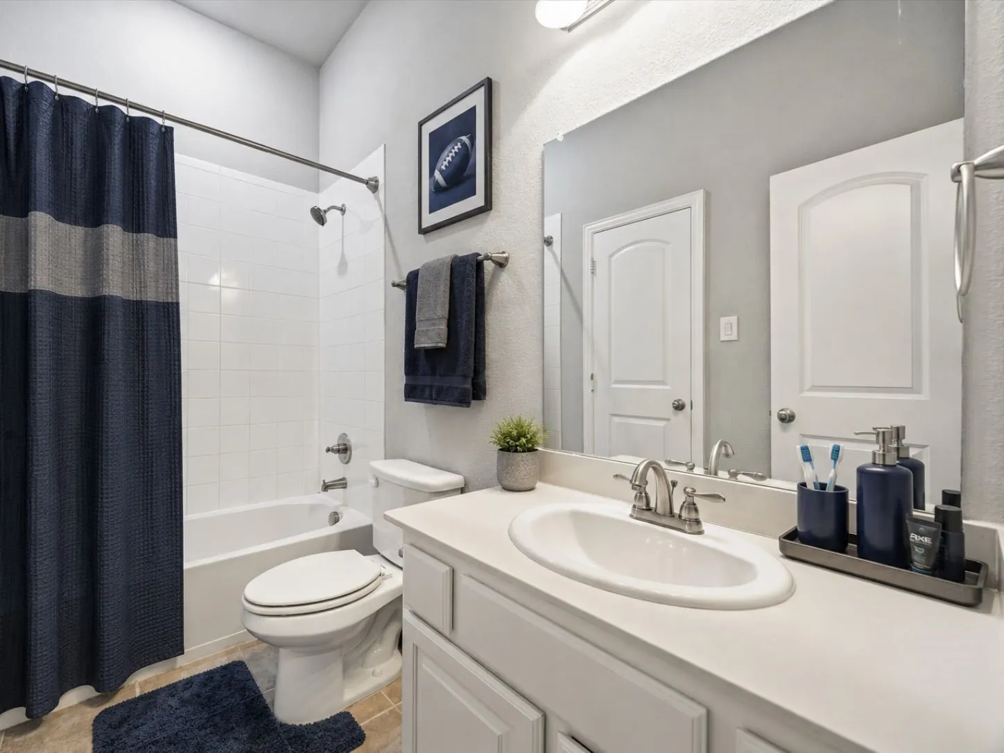 Built-in vanity with an undermount sink, white countertop, and chrome faucet