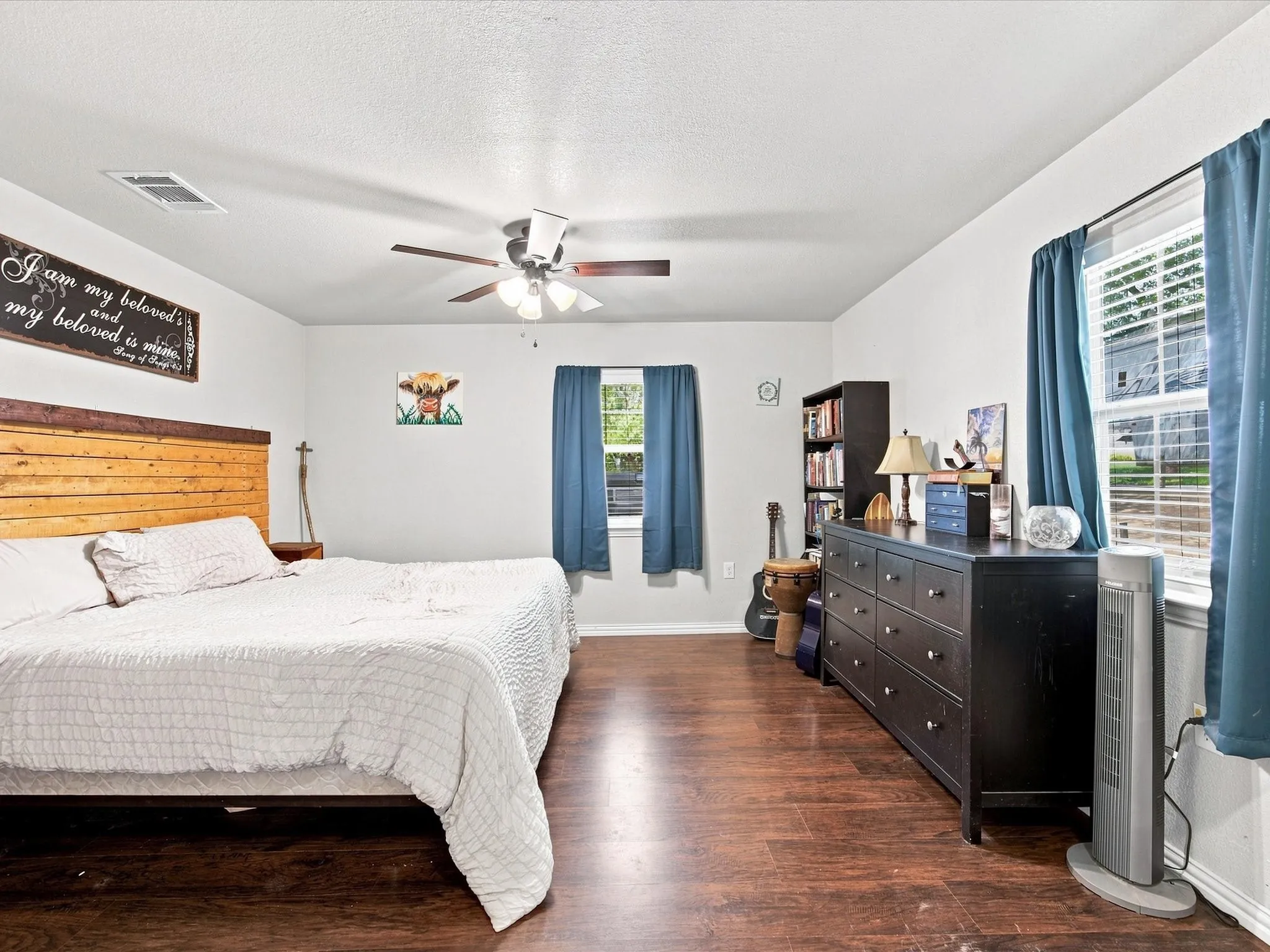 Wood-finish flooring, white walls, and a ceiling fan with integrated lighting