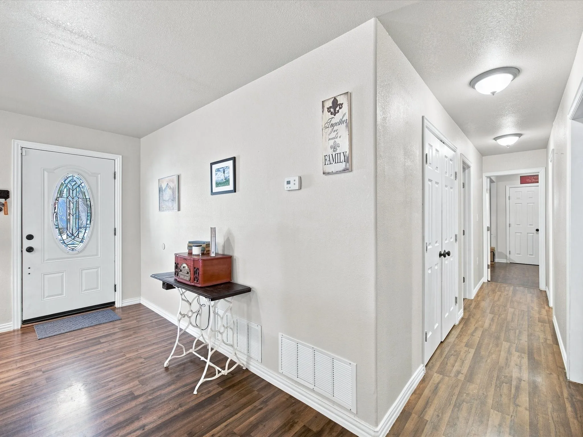 Wood-finish flooring, white paneled doors, and ceiling-mounted flush lighting fixtures