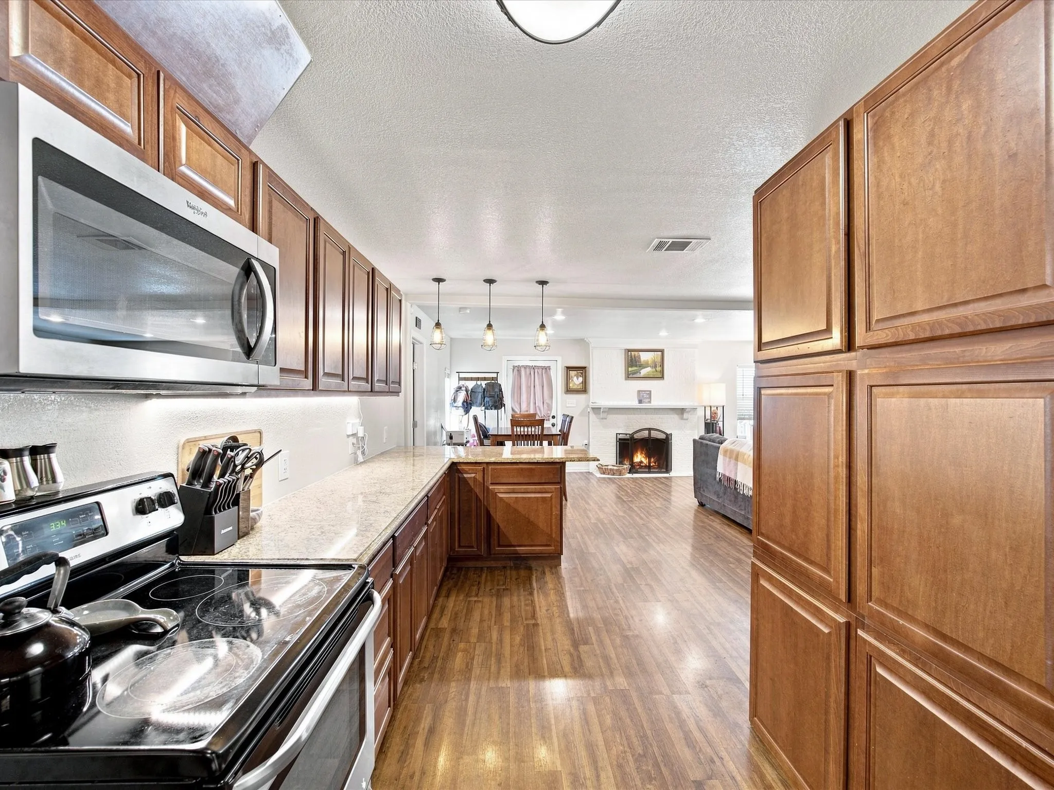 Kitchen featuring stainless steel appliances, wood-finish flooring, recessed lighting, wood cabinetry, and a built-in microwave