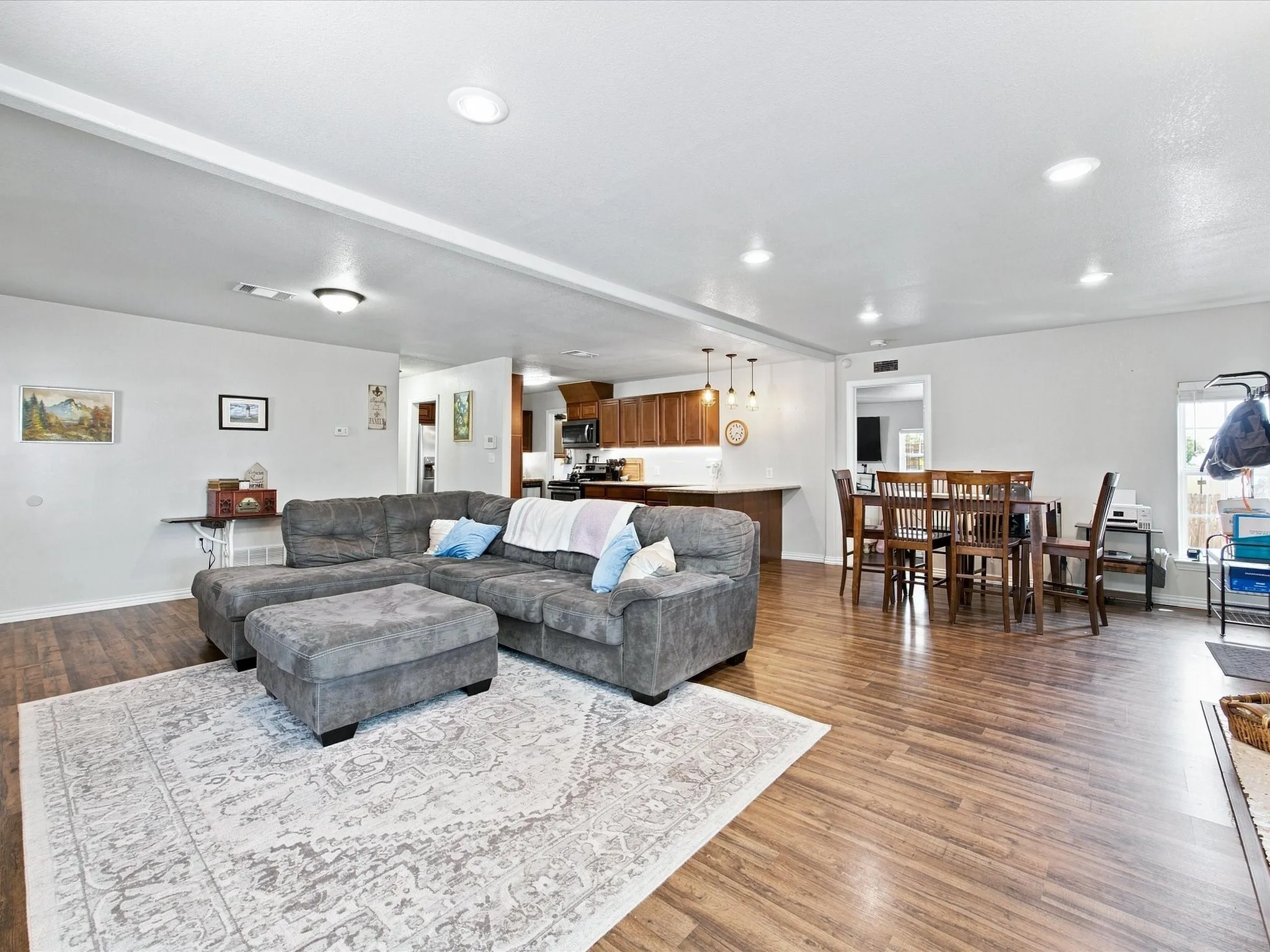 Open concept living area featuring wood-finish flooring, recessed lighting, and a kitchen with warm wood cabinetry