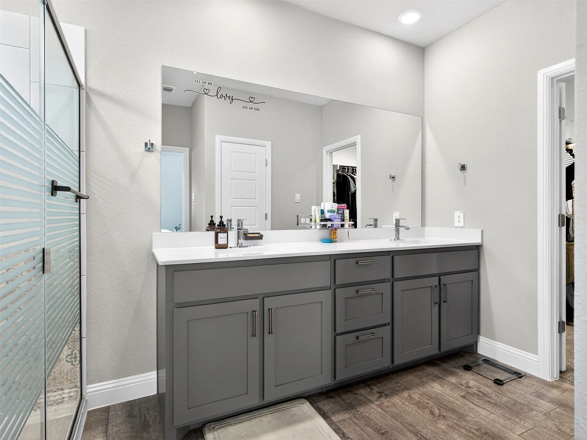 Dual vanity with grey cabinetry, white countertops, and integrated sinks
