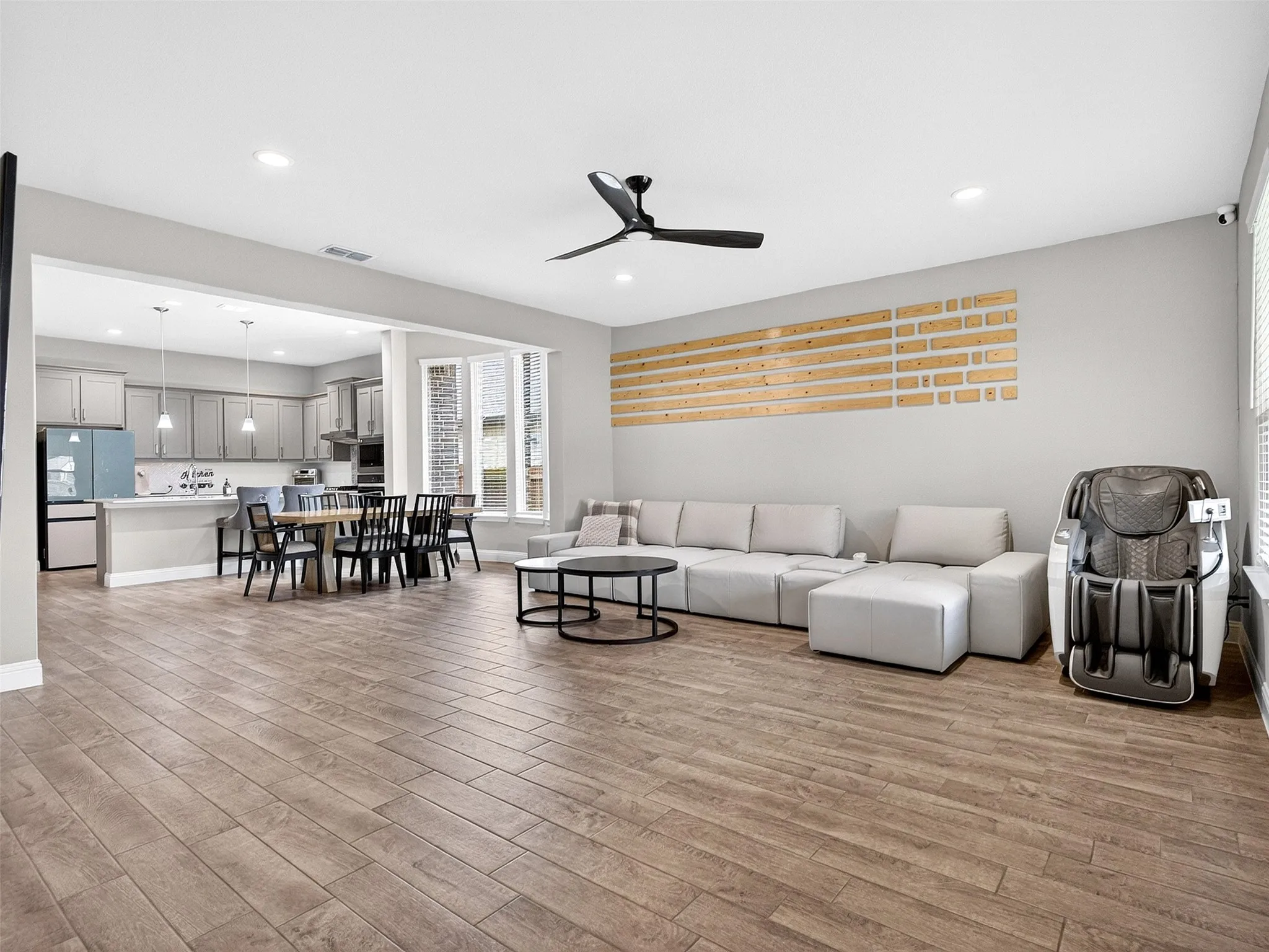 Open-concept living space featuring wood-finish flooring, recessed lighting, and a ceiling fan