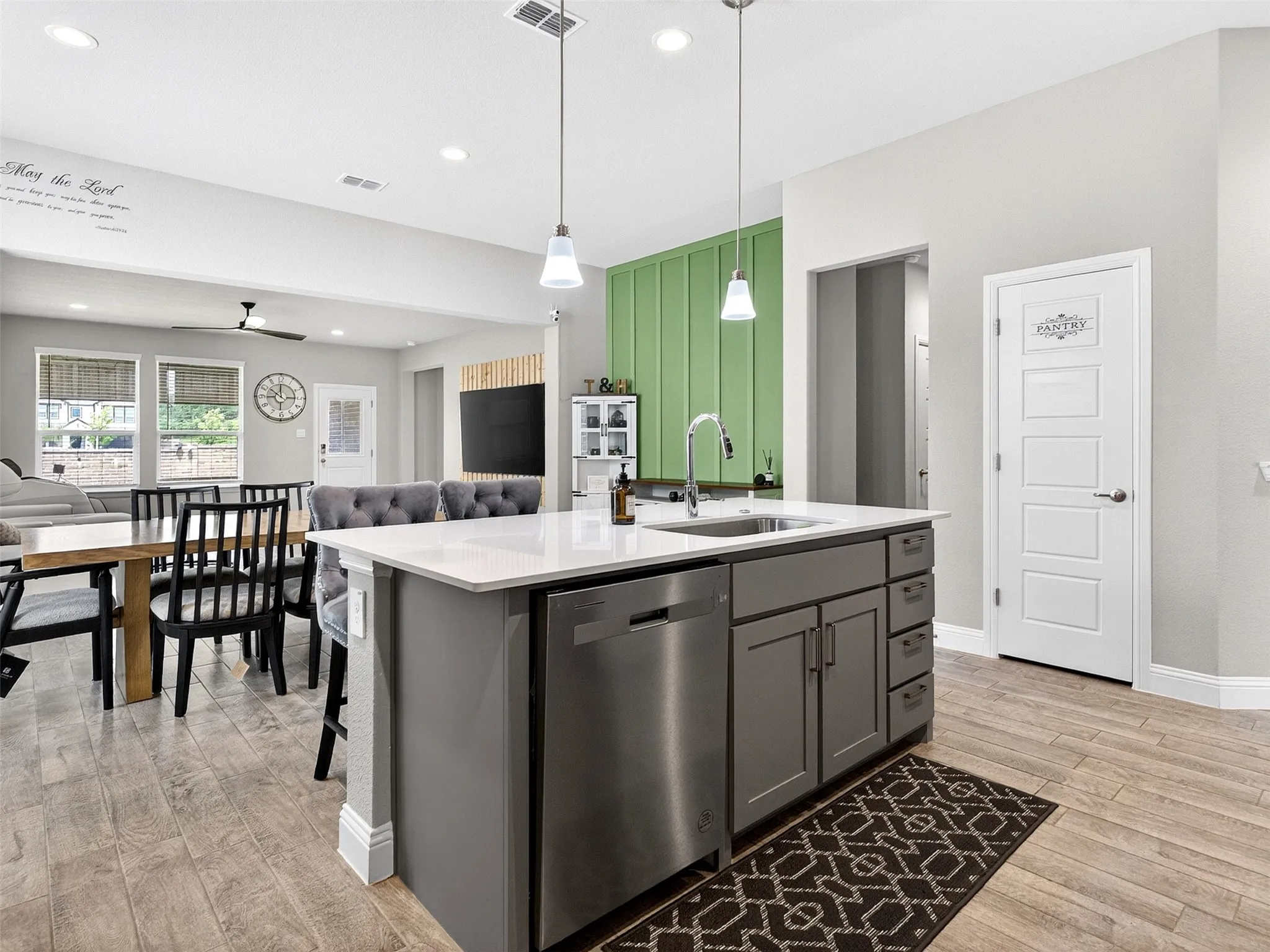 Kitchen island with white countertop, undermount sink, and stainless steel dishwasher