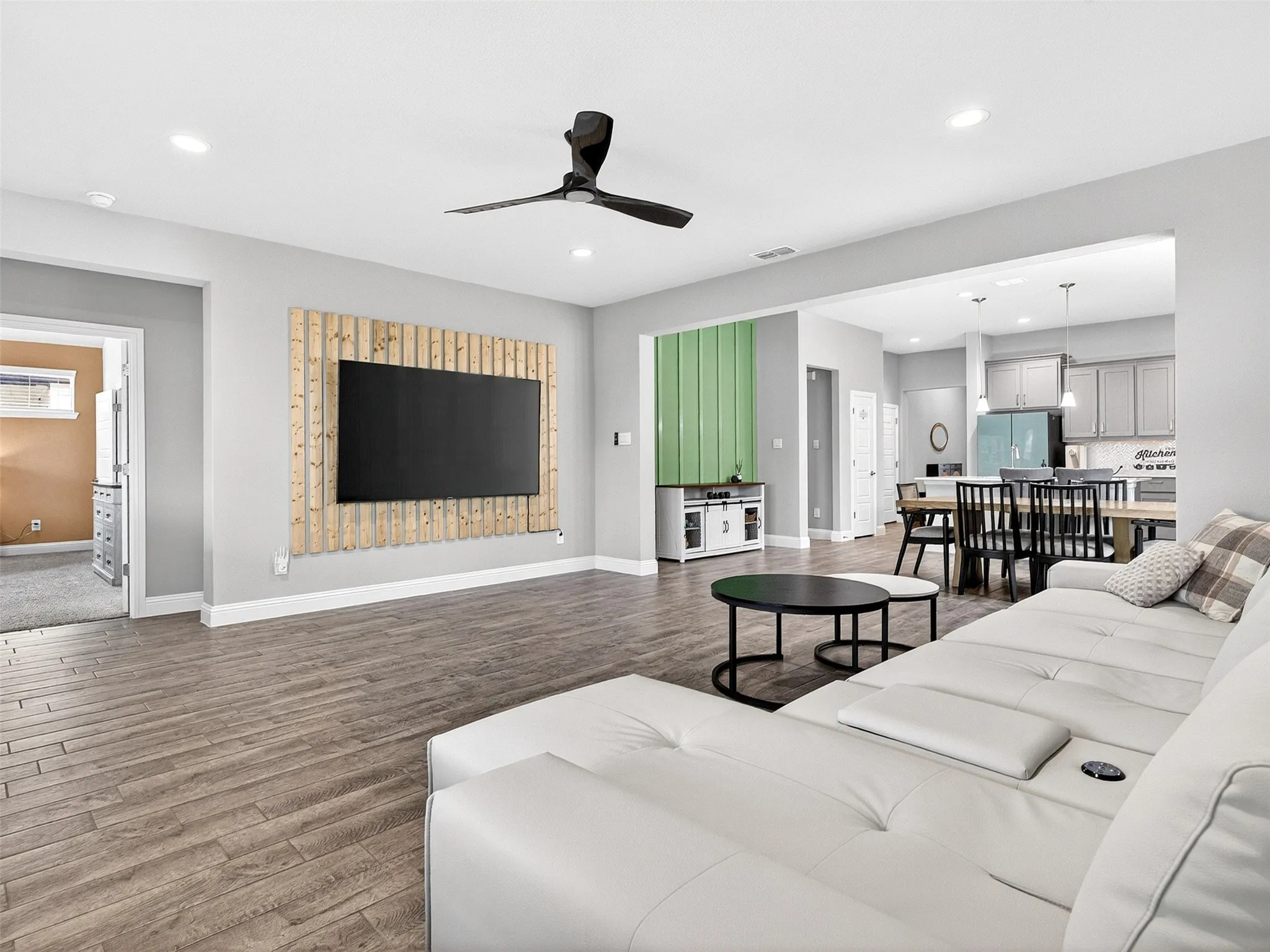 Open-concept living space with wood-finish flooring, recessed lighting, and a ceiling fan