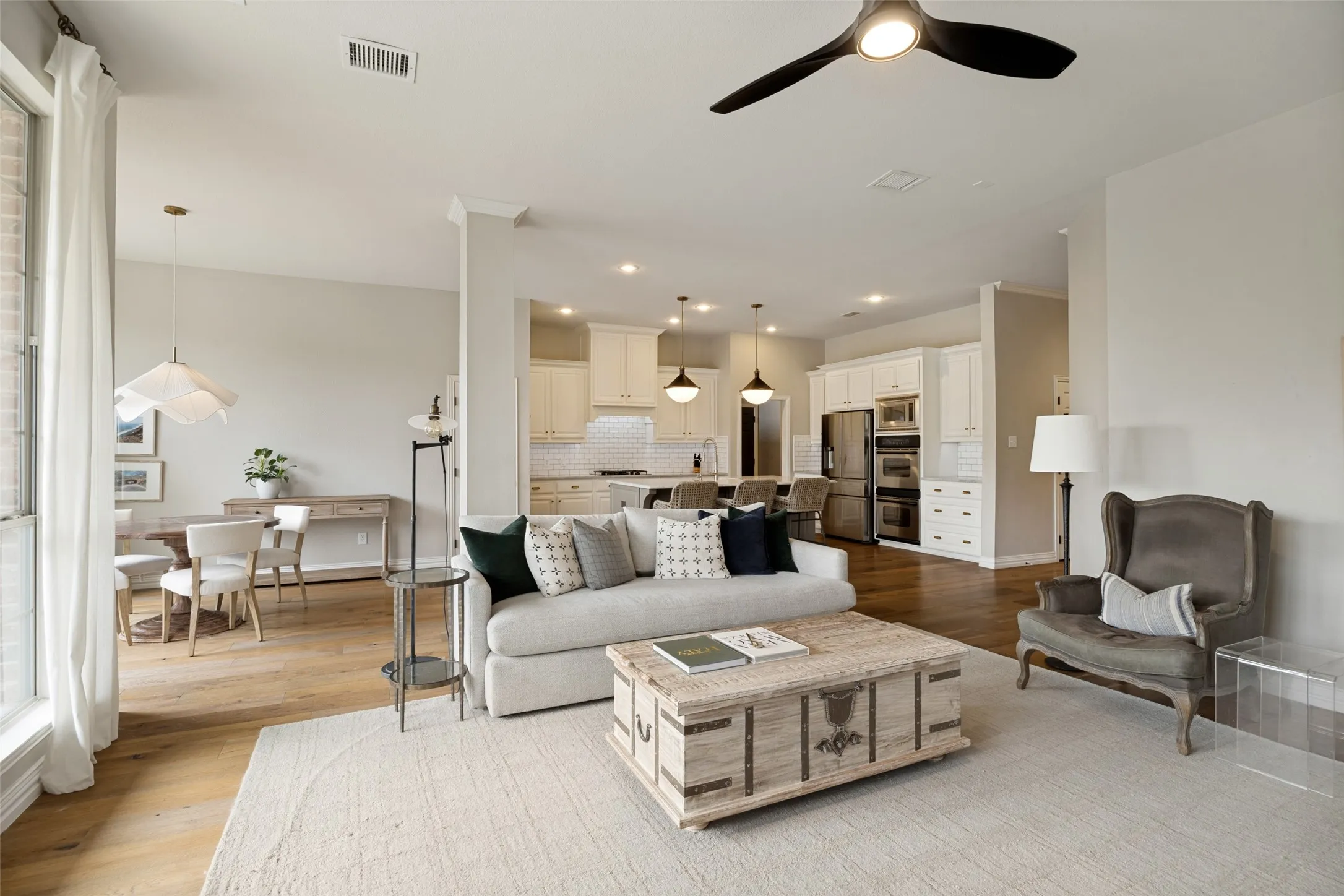 Open-concept living space featuring wood-finish flooring, recessed lighting, and a contemporary ceiling fan