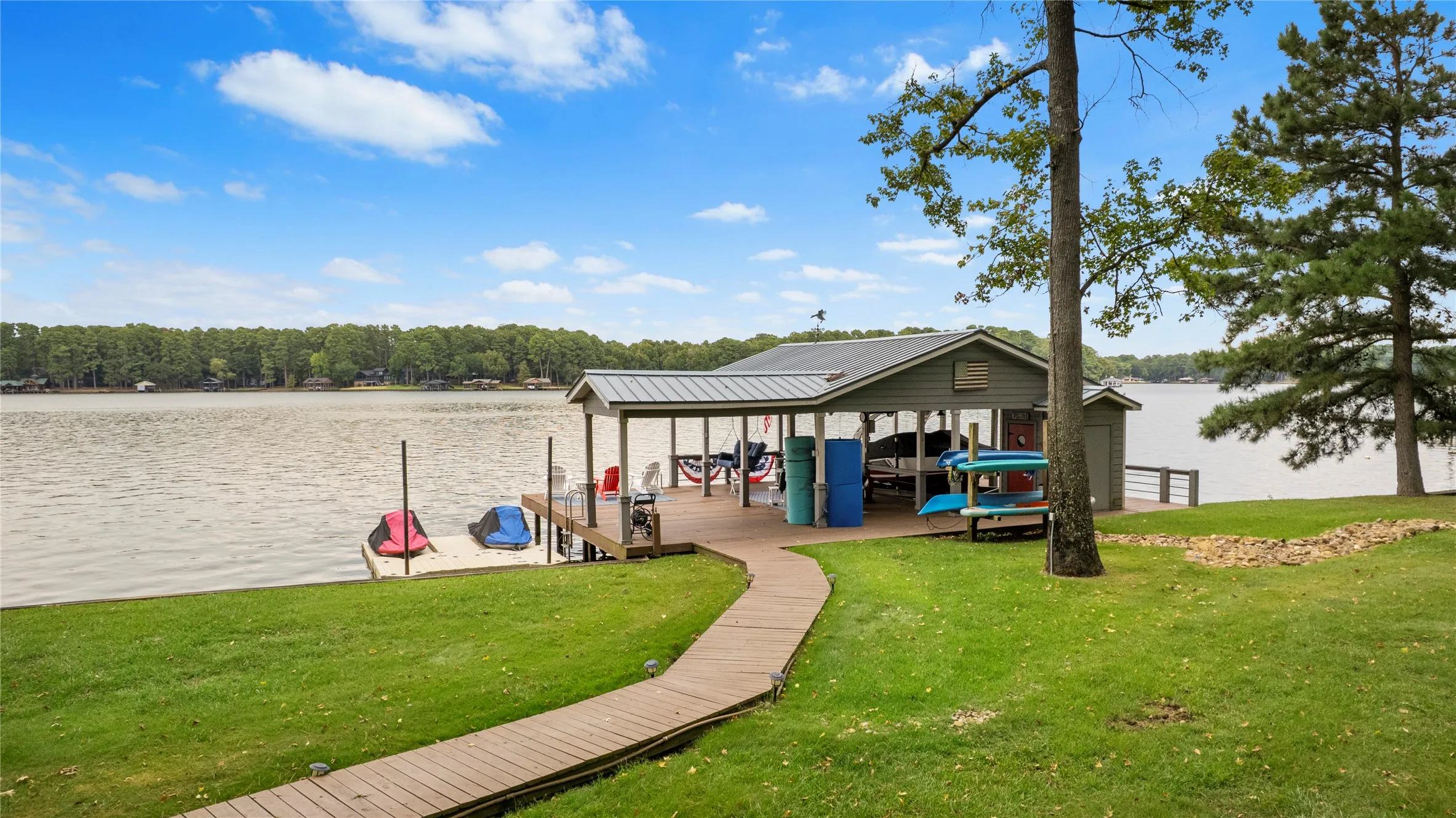 For water recreation enthusiasts ~ the boathouse offers an expanded open & covered dock for your watercraft, lounge chairs, floats & more.  Note the floating jet ski lift that will remain as well.  Ski Boat, Jet Skis  & a trailer available for separate purchase.