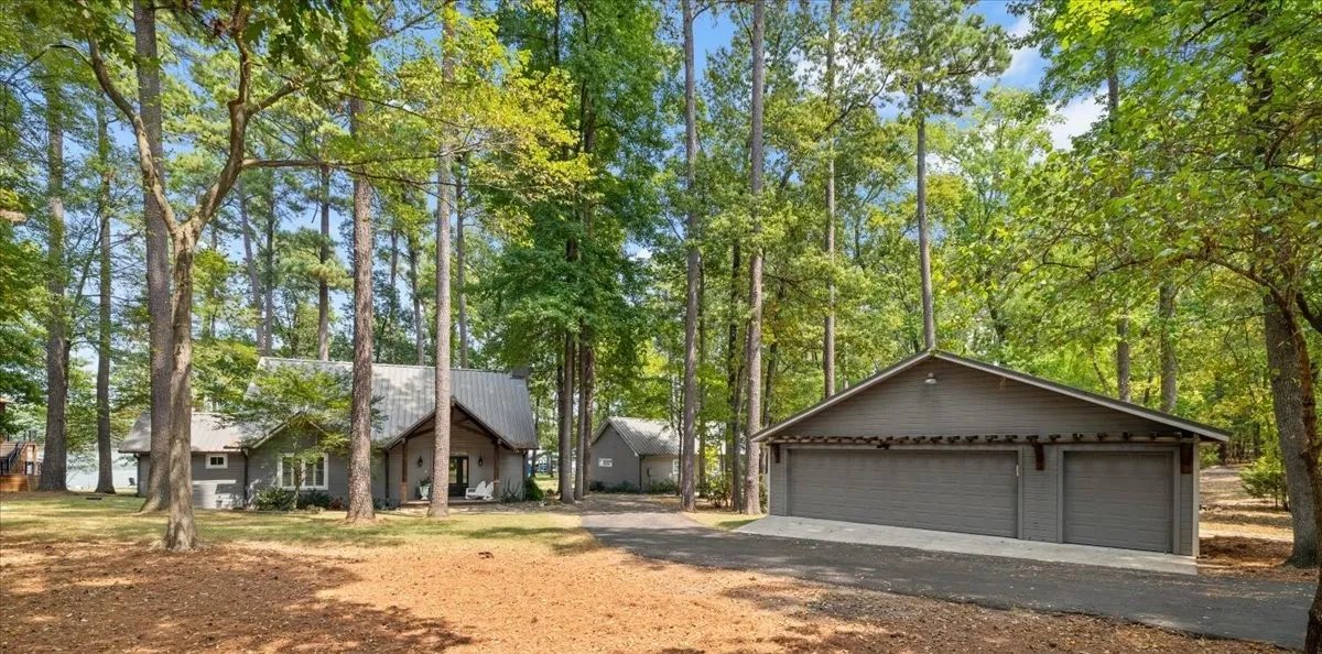 Dramatic curb appeal nestled among majestic trees that give East Texas its enduring charm. 3 total structures -- the main house, cottage/guest house + a 3-car garage.